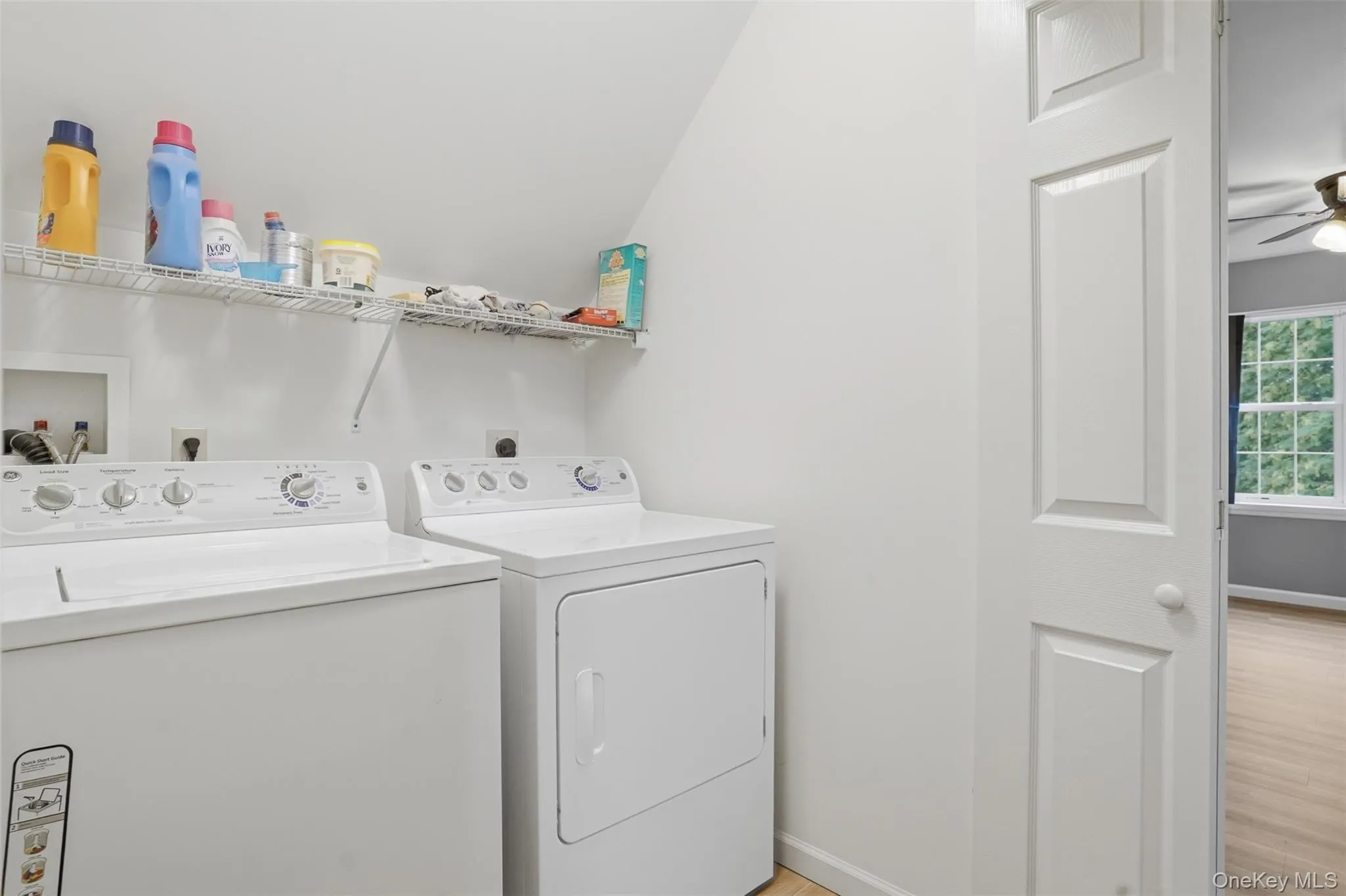Dedicated laundry area featuring a washer and dryer, wire shelving for storage, and light-toned flooring Dedicated laundry area featuring a washer and dryer, wire shelving for storage, and light-toned flooring
