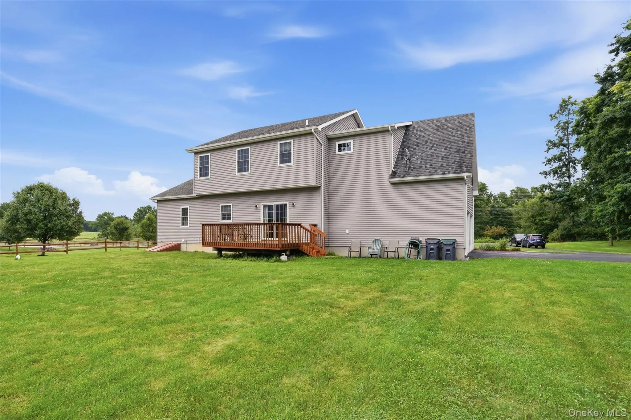 Expansive green lawn with a two-story residence featuring light gray siding Expansive green lawn with a two-story residence featuring light gray siding