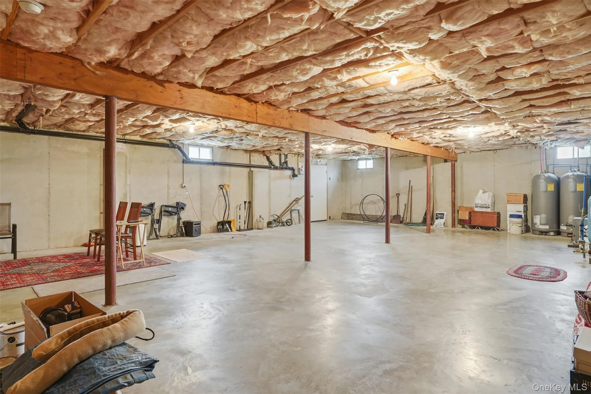 Spacious basement featuring concrete flooring, exposed ceiling joists, and insulated ceiling Spacious basement featuring concrete flooring, exposed ceiling joists, and insulated ceiling