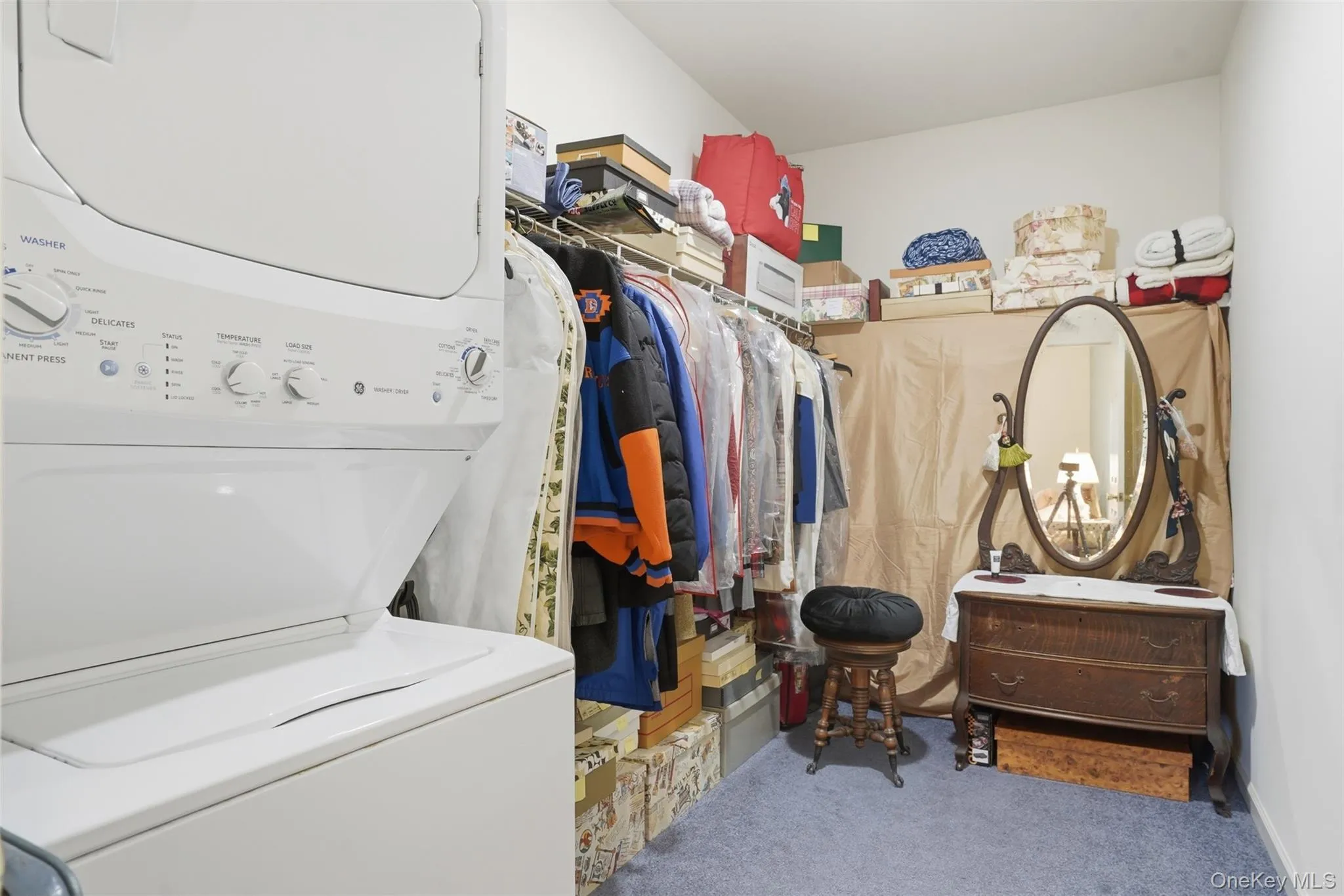 Integrated laundry area featuring a stacked washer and dryer unit Integrated laundry area featuring a stacked washer and dryer unit