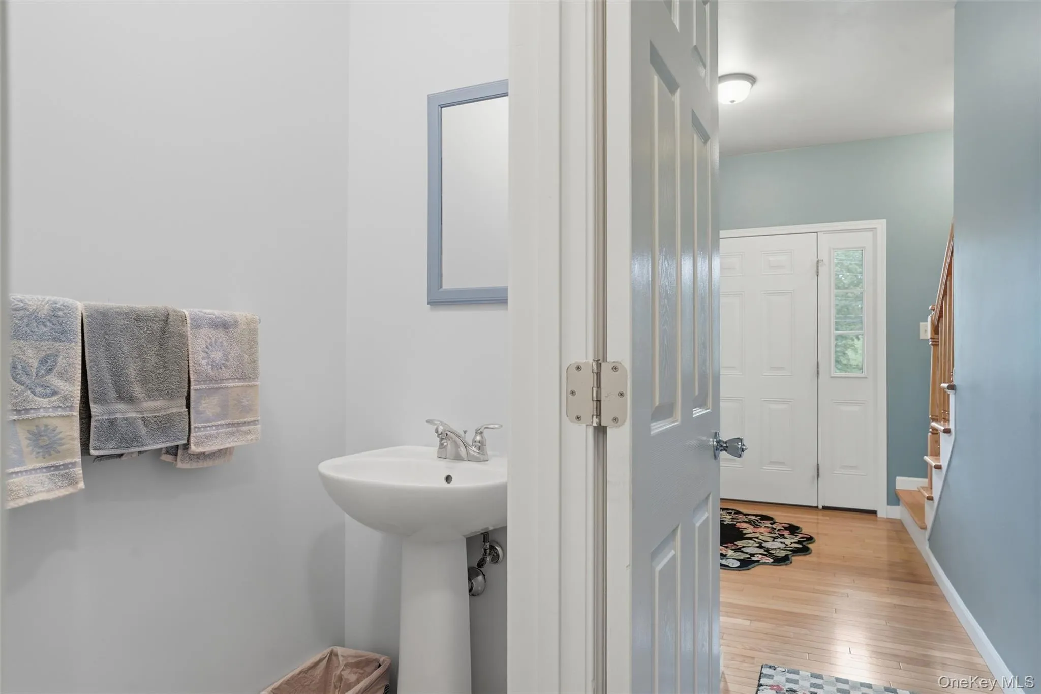 Pedestal sink with chrome faucet, framed mirror, and light gray walls Pedestal sink with chrome faucet, framed mirror, and light gray walls