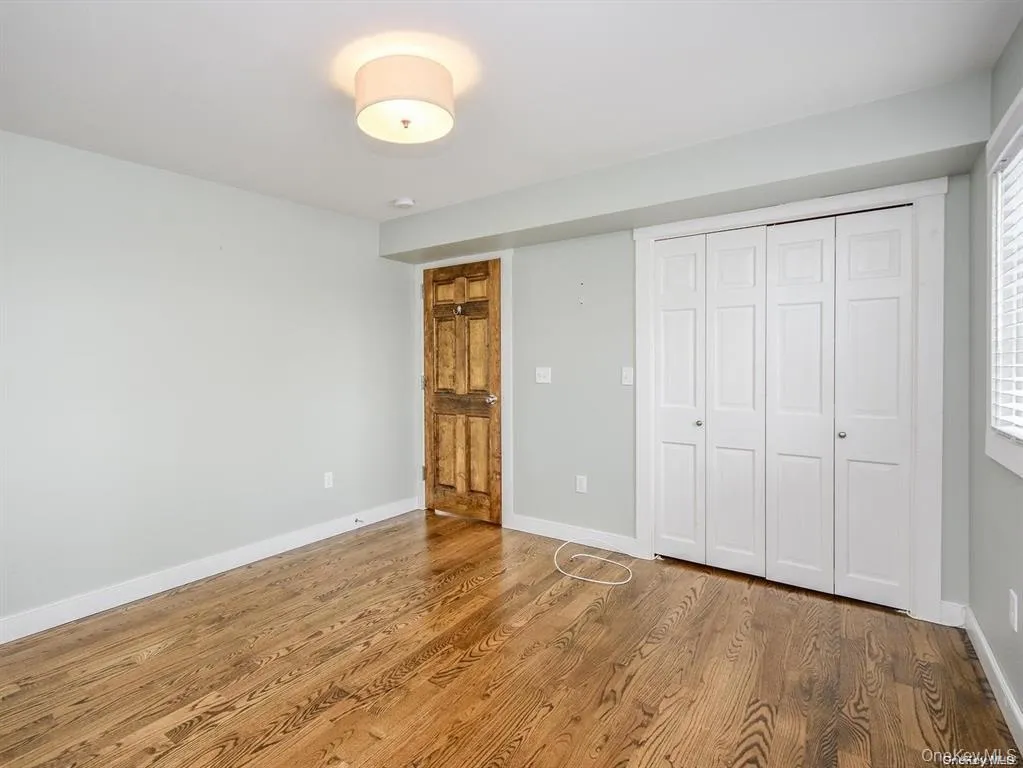 Unfurnished bedroom with wood finished floors and a closet Unfurnished bedroom with wood finished floors and a closet