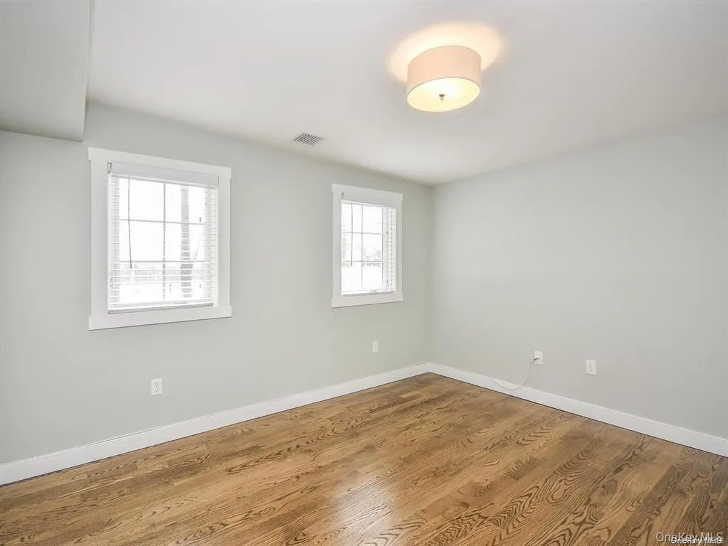 Spare room featuring baseboards and wood finished floors Spare room featuring baseboards and wood finished floors