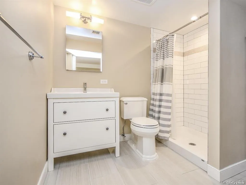 Full bathroom featuring a tile shower and vanity Full bathroom featuring a tile shower and vanity
