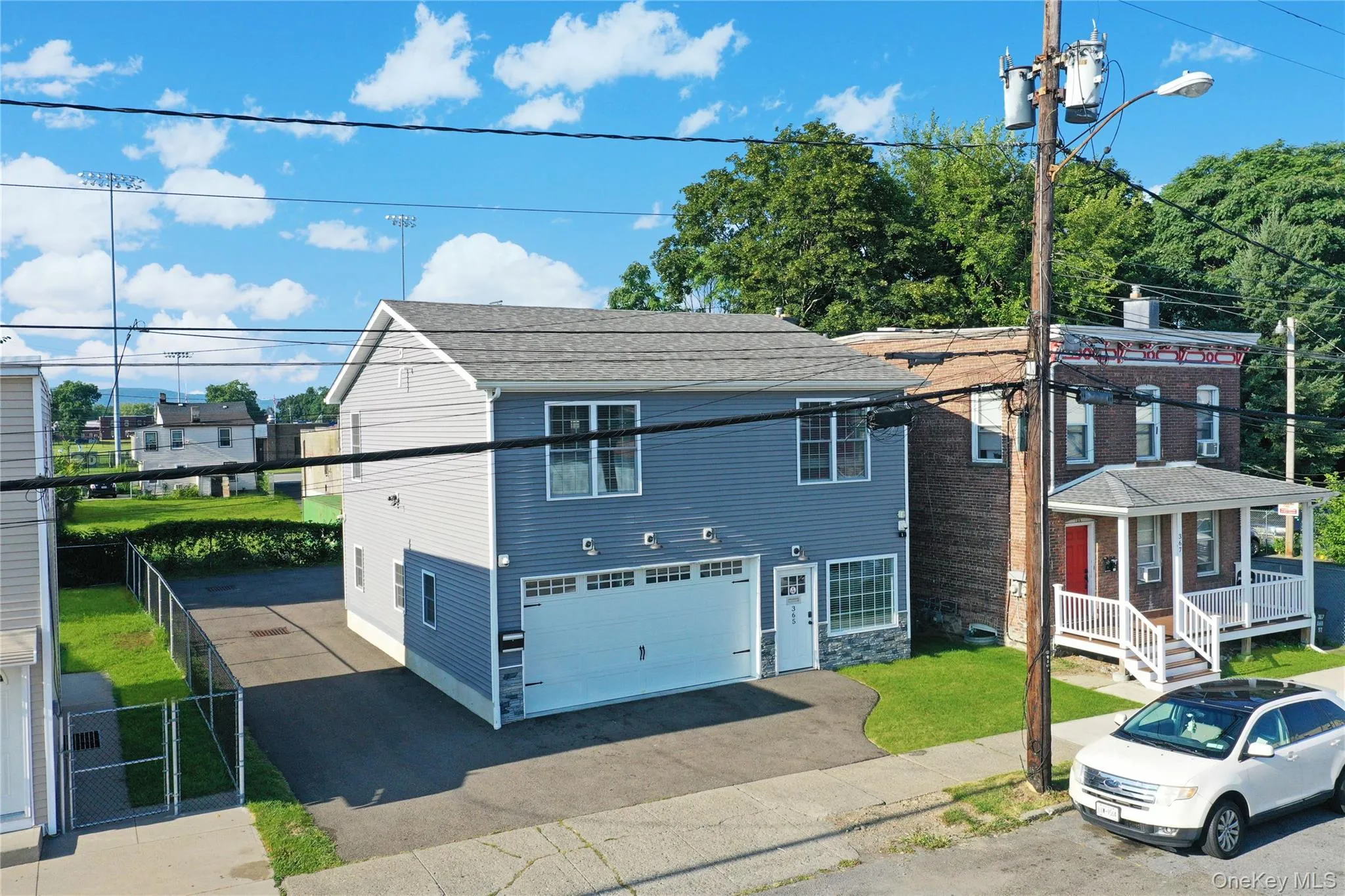 View of front facade featuring driveway, a gate, and an attached garage View of front facade featuring driveway, a gate, and an attached garage