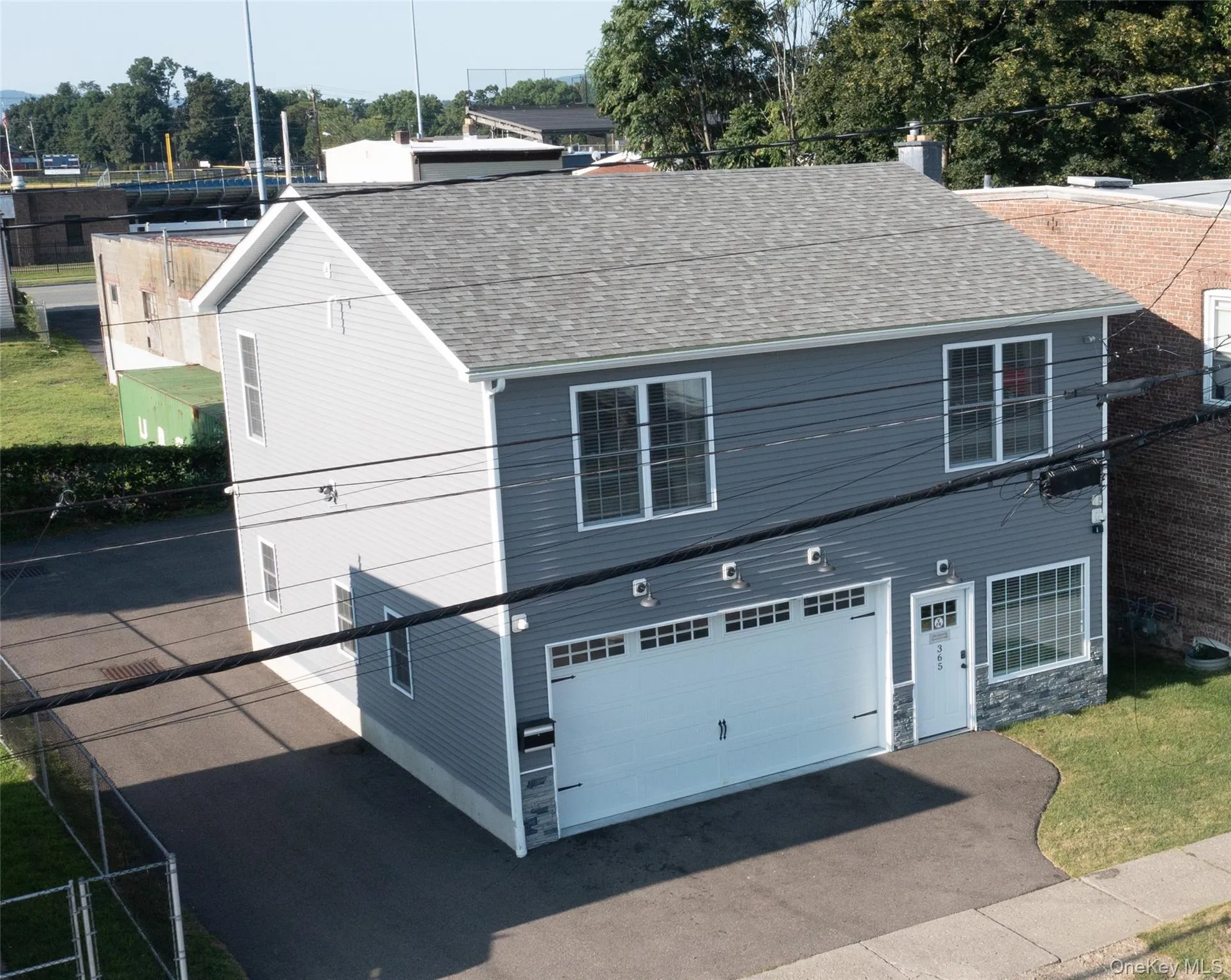 View of front of property with a shingled roof, an attached garage, and asphalt driveway View of front of property with a shingled roof, an attached garage, and asphalt driveway