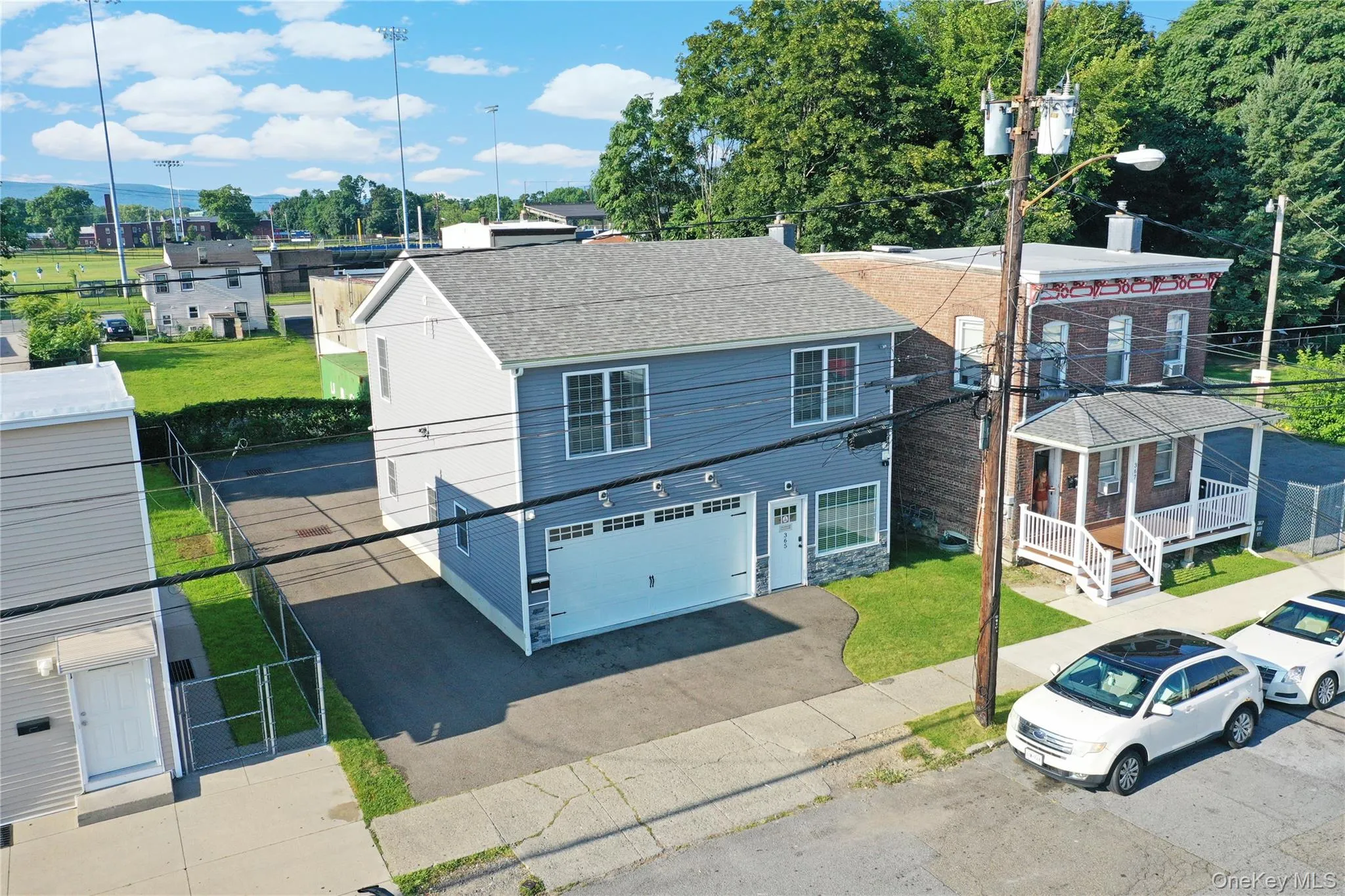 View of front of house with driveway, a shingled roof, a garage, a residential view, and a gate View of front of house with driveway, a shingled roof, a garage, a residential view, and a gate