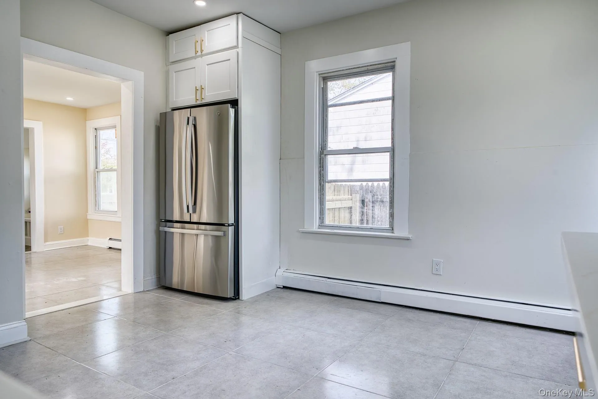 Kitchen with freestanding refrigerator, baseboard heating, white cabinets, baseboards, and recessed lighting Kitchen with freestanding refrigerator, baseboard heating, white cabinets, baseboards, and recessed lighting