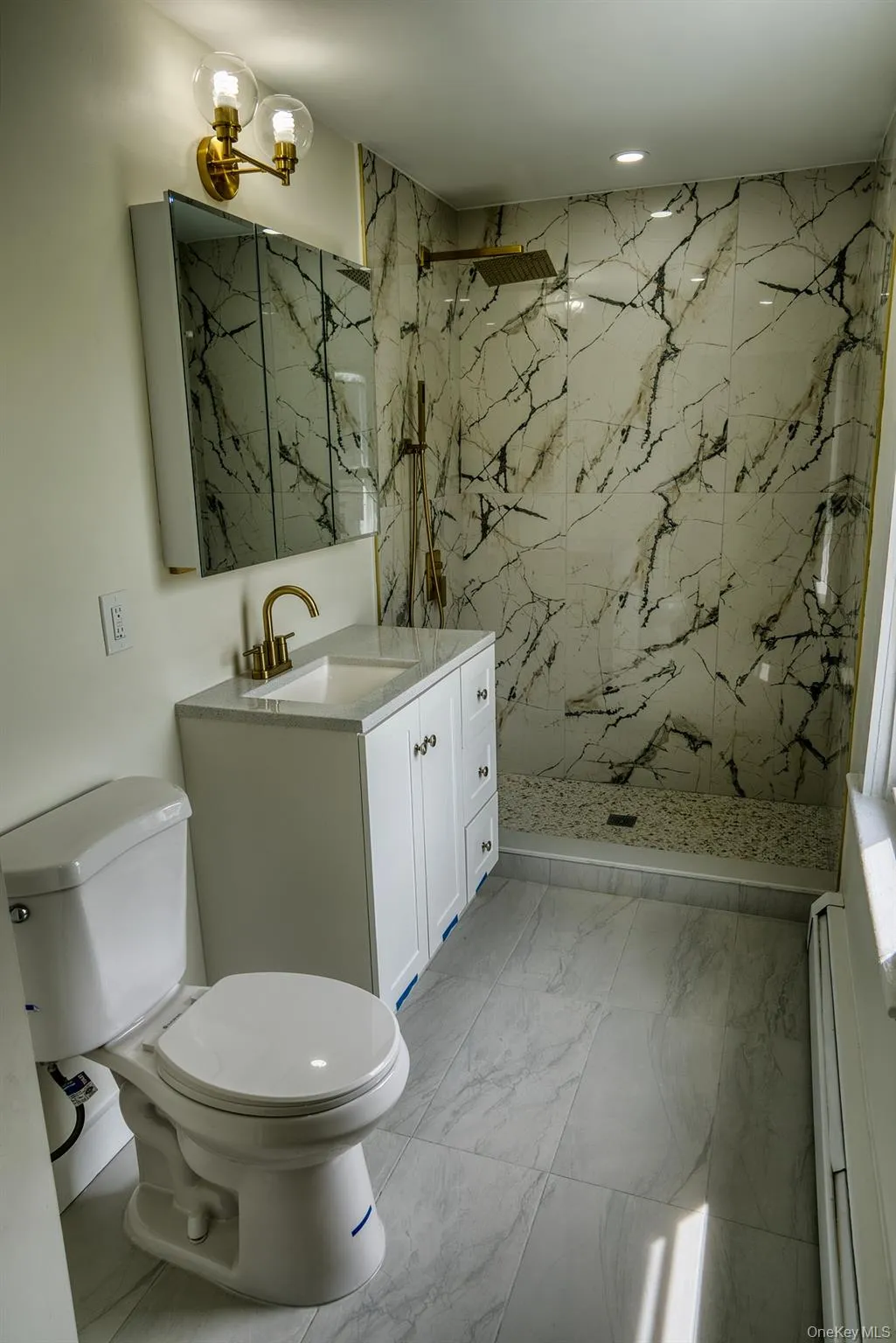 Full bath with a baseboard heating unit, vanity, toilet, a marble finish shower, and recessed lighting Full bath with a baseboard heating unit, vanity, toilet, a marble finish shower, and recessed lighting