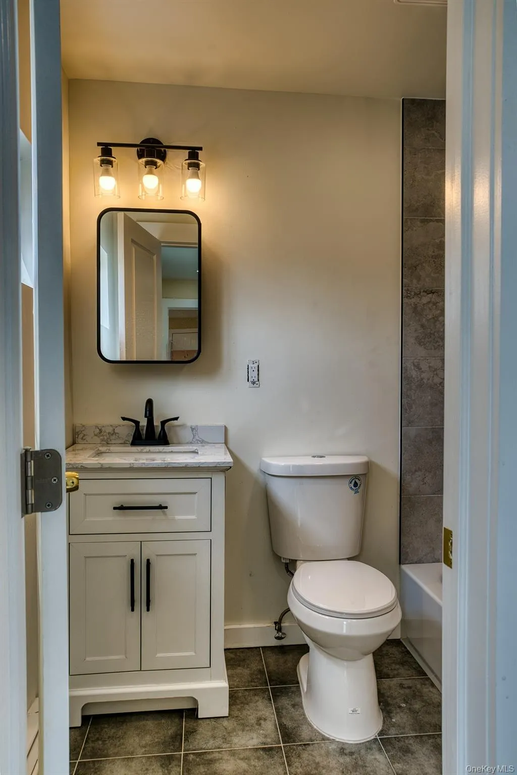 Full bath with tile patterned floors, vanity, toilet, and baseboards Full bath with tile patterned floors, vanity, toilet, and baseboards