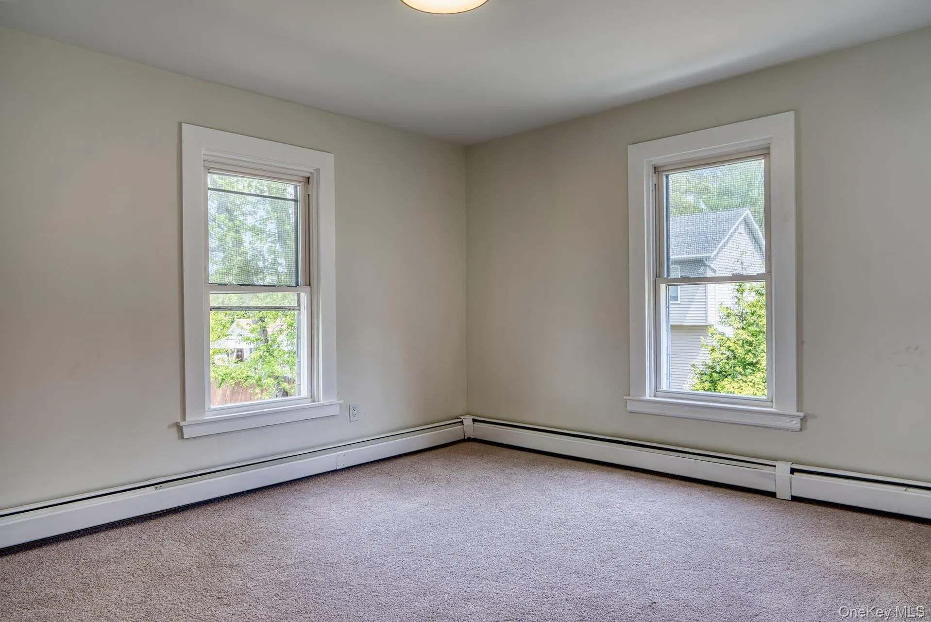 Spare room featuring plenty of natural light and carpet floors Spare room featuring plenty of natural light and carpet floors