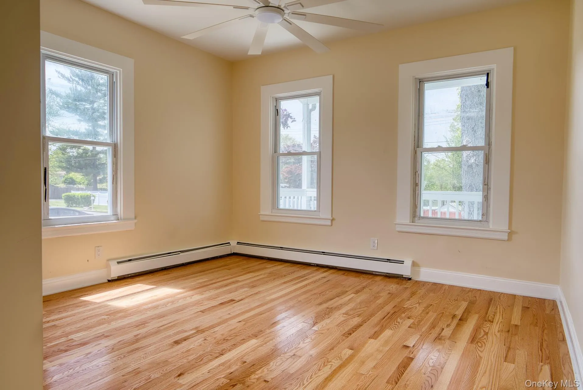 Spare room with light wood-type flooring, ceiling fan, and baseboards Spare room with light wood-type flooring, ceiling fan, and baseboards