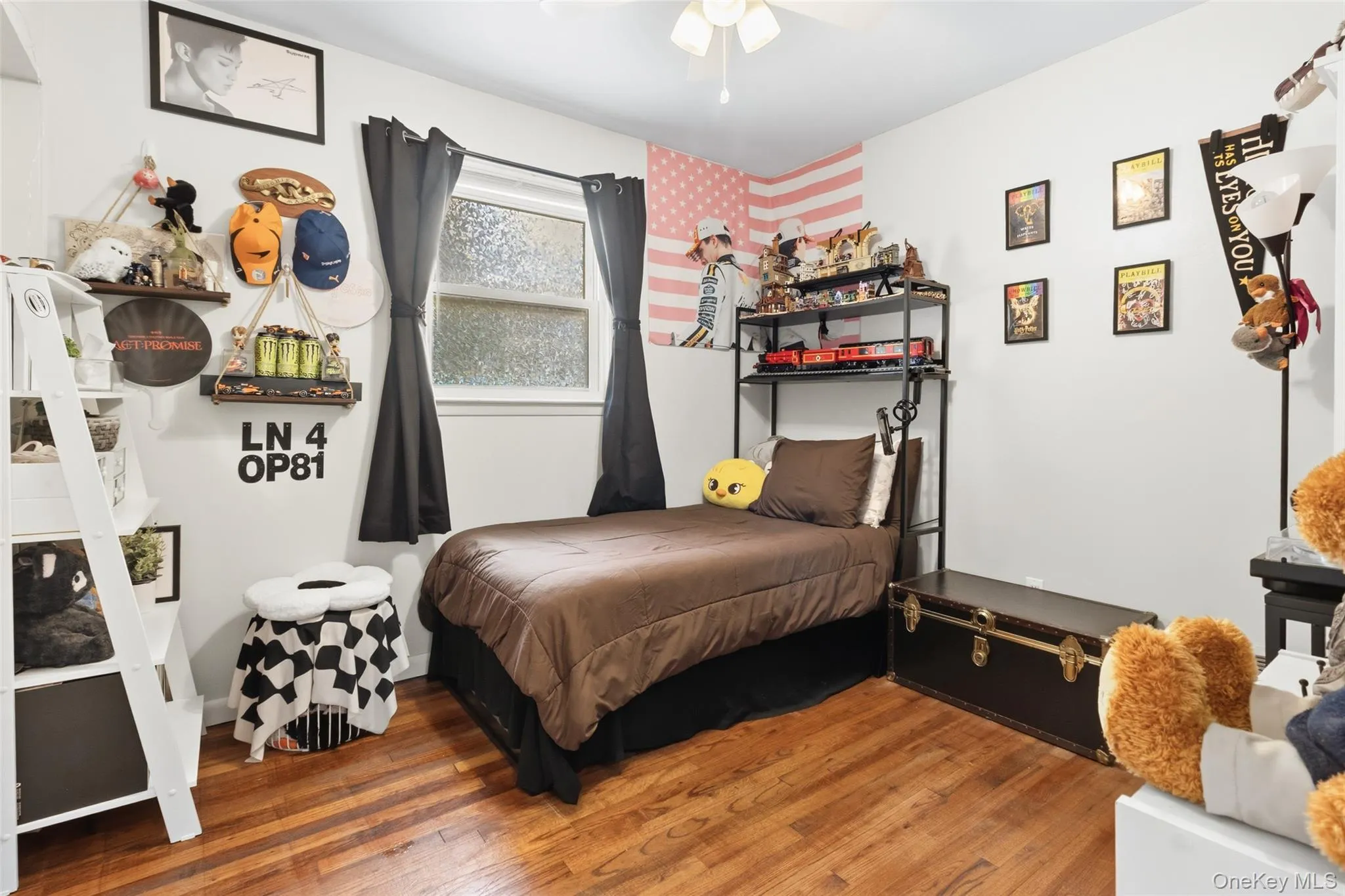 Bedroom featuring wood-finish flooring and a white ceiling with a flush-mount light fixture Bedroom featuring wood-finish flooring and a white ceiling with a flush-mount light fixture