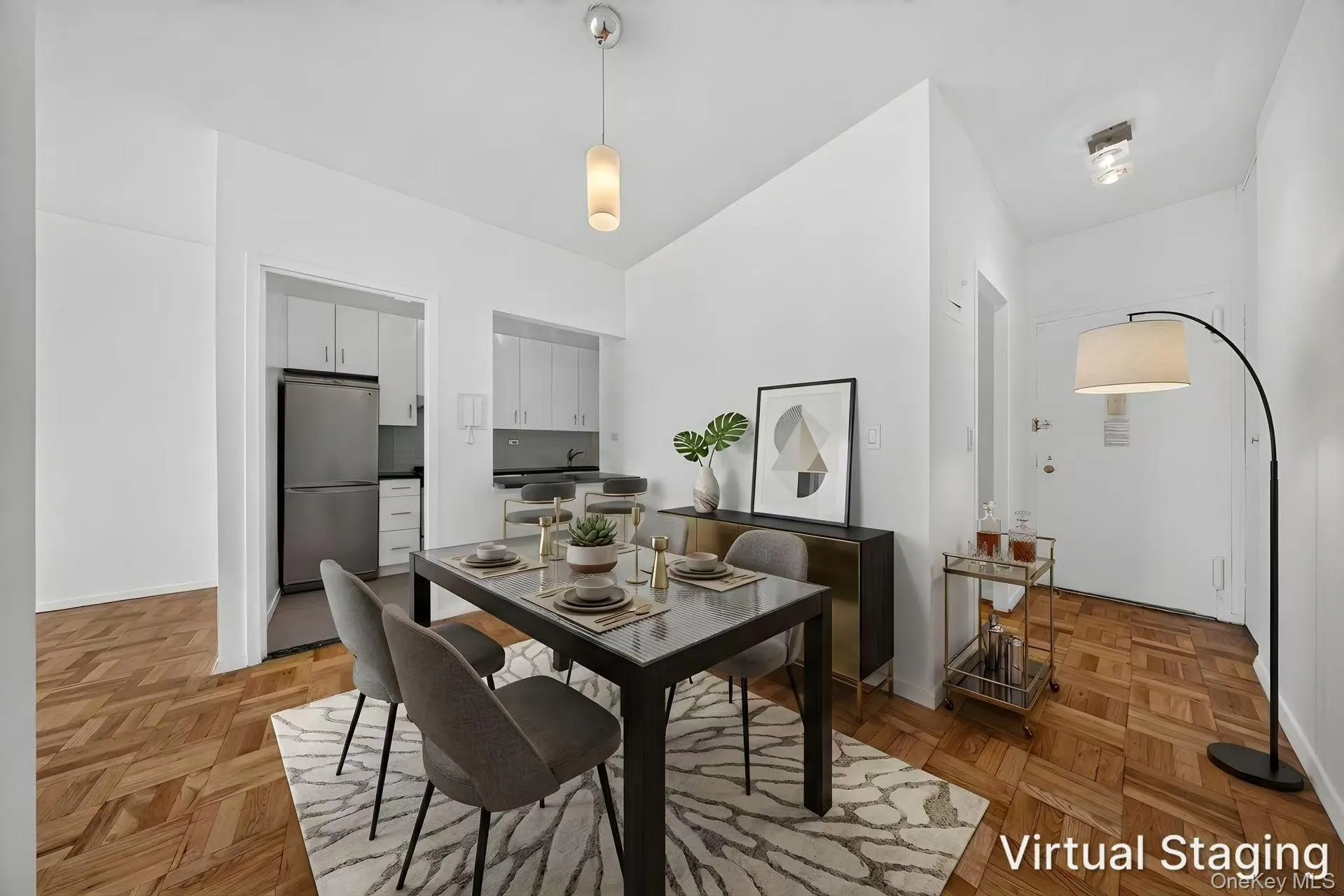 Parquet wood-finish flooring extends throughout this interior space, featuring a recessed kitchen with upper and lower cabinetry Parquet wood-finish flooring extends throughout this interior space, featuring a recessed kitchen with upper and lower cabinetry