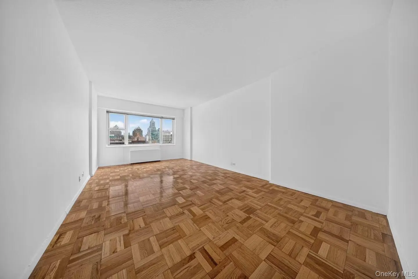 Bright interior space featuring parquet wood flooring and large windows Bright interior space featuring parquet wood flooring and large windows