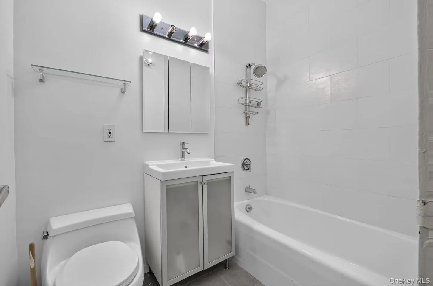 Modern bathroom featuring a white porcelain toilet, a vanity with a white basin and chrome faucet, and a medicine cabinet with mirrored doors Modern bathroom featuring a white porcelain toilet, a vanity with a white basin and chrome faucet, and a medicine cabinet with mirrored doors