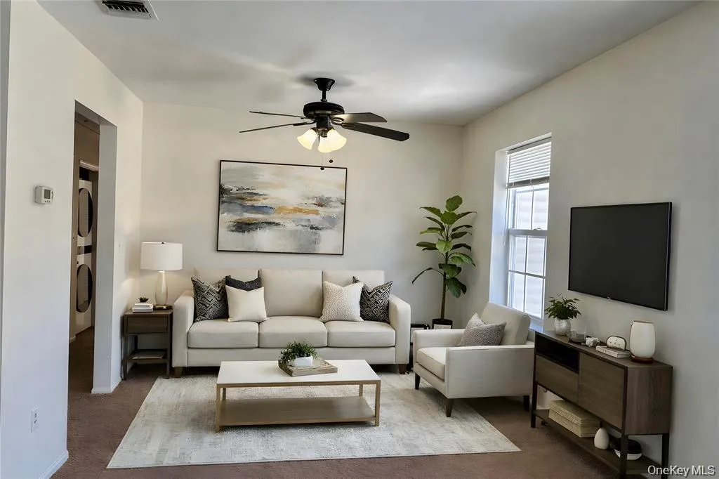 Virtual Staged- Living space featuring a ceiling fan, window with blinds, and a built-in entertainment console Virtual Staged- Living space featuring a ceiling fan, window with blinds, and a built-in entertainment console