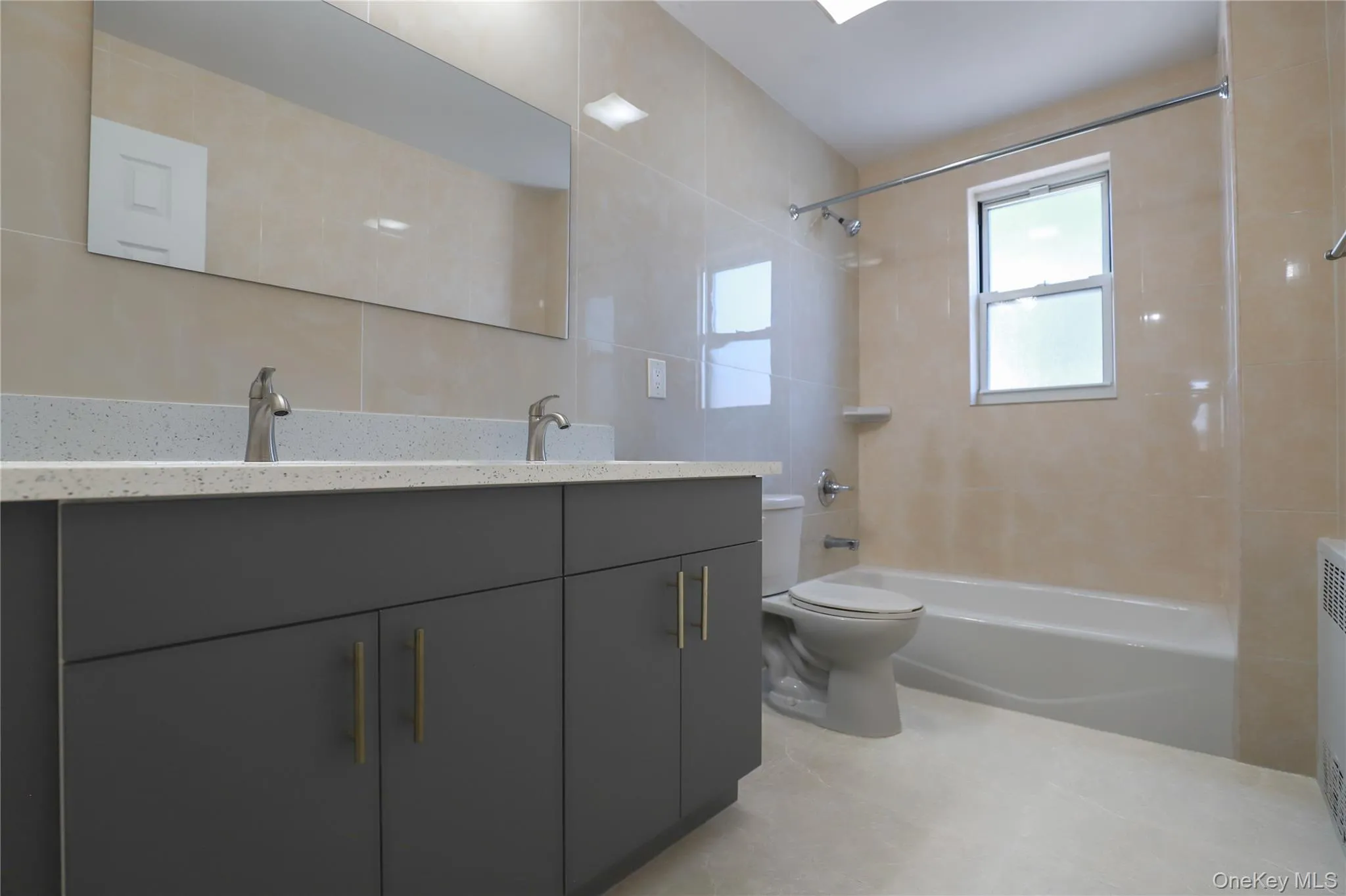 Spacious full bathroom featuring a double vanity with his-and-hers sinks and a tub/shower combination Spacious full bathroom featuring a double vanity with his-and-hers sinks and a tub/shower combination