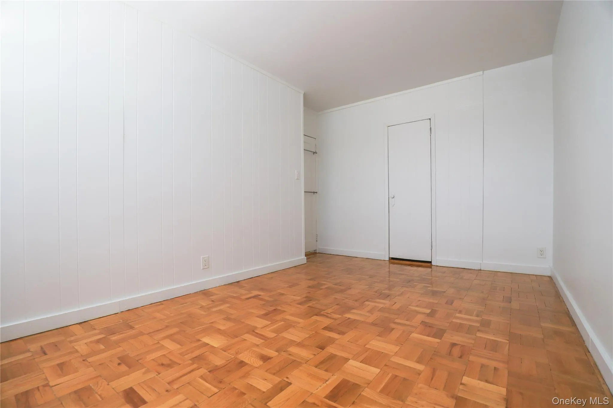 Spacious bedroom with beautiful parquet hardwood floors, abundant natural light, and built-in closet space Spacious bedroom with beautiful parquet hardwood floors, abundant natural light, and built-in closet space