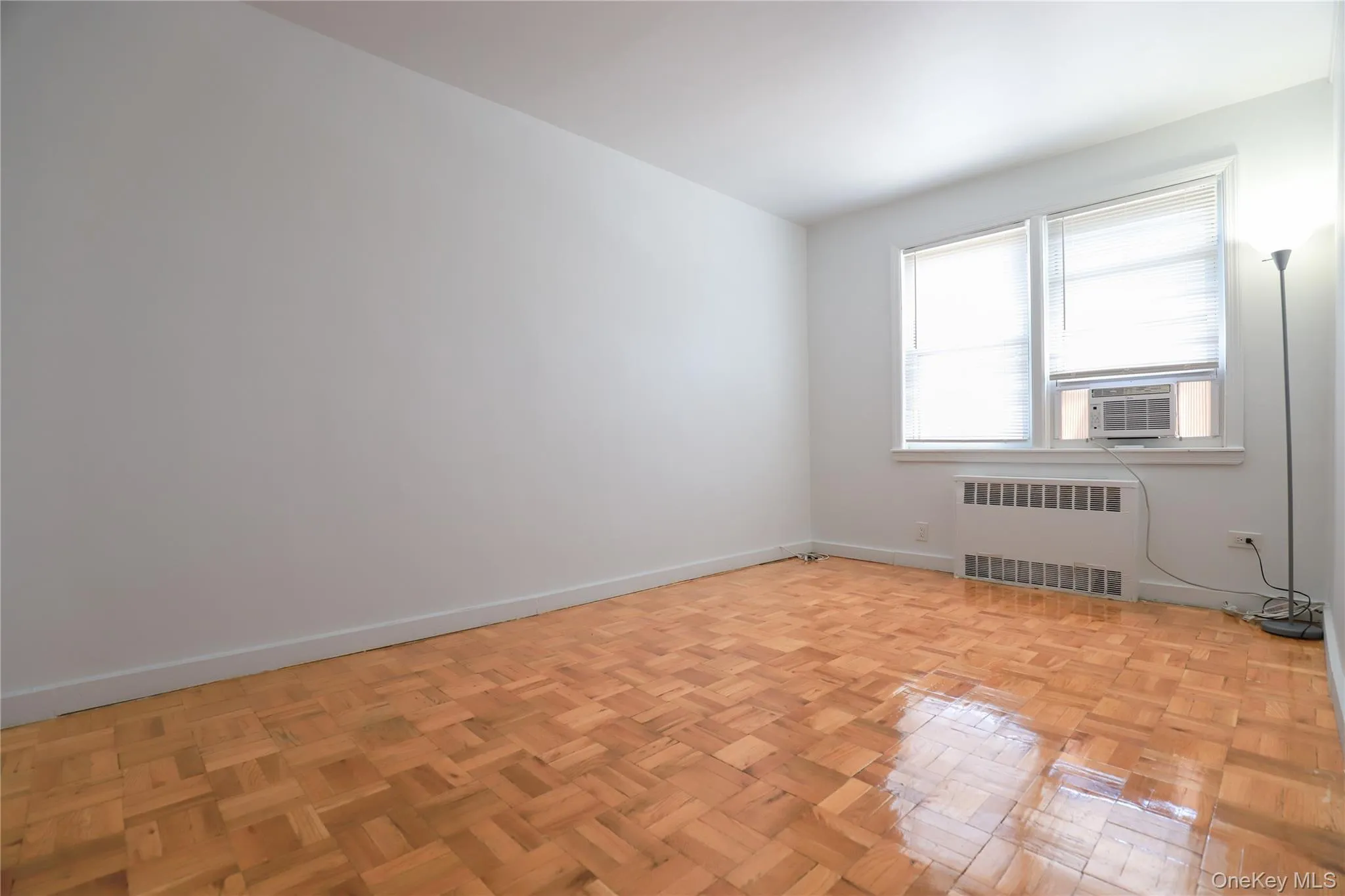 Spacious bedroom with beautiful parquet hardwood floors, abundant natural light, and built-in closet space Spacious bedroom with beautiful parquet hardwood floors, abundant natural light, and built-in closet space