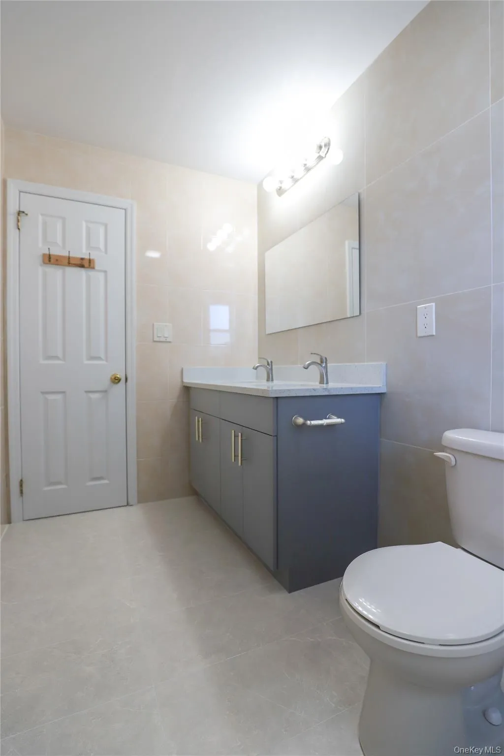 Bathroom featuring a double vanity with gray cabinetry and a white countertop Bathroom featuring a double vanity with gray cabinetry and a white countertop