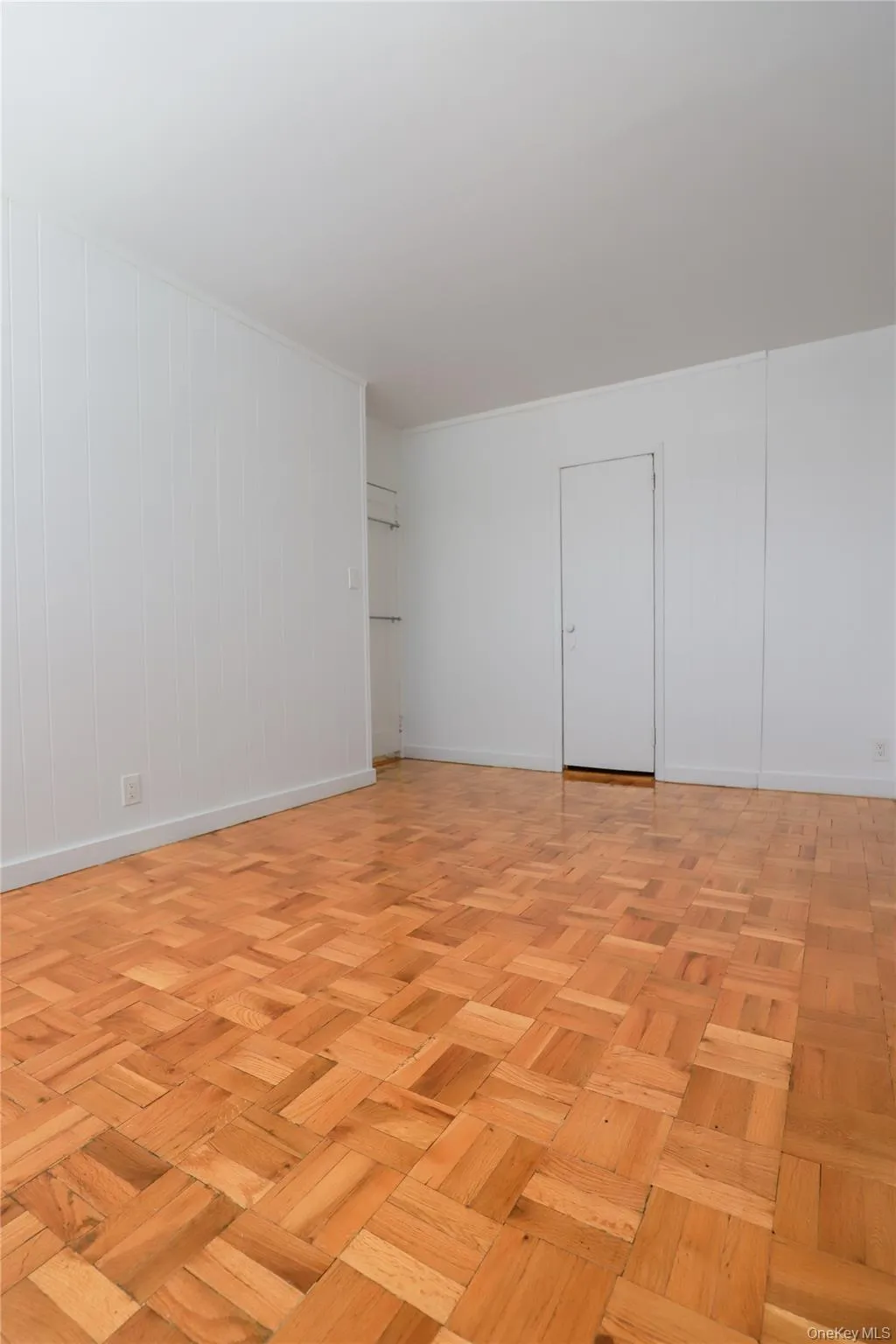 Spacious bedroom with beautiful parquet hardwood floors, abundant natural light, and built-in closet space Spacious bedroom with beautiful parquet hardwood floors, abundant natural light, and built-in closet space