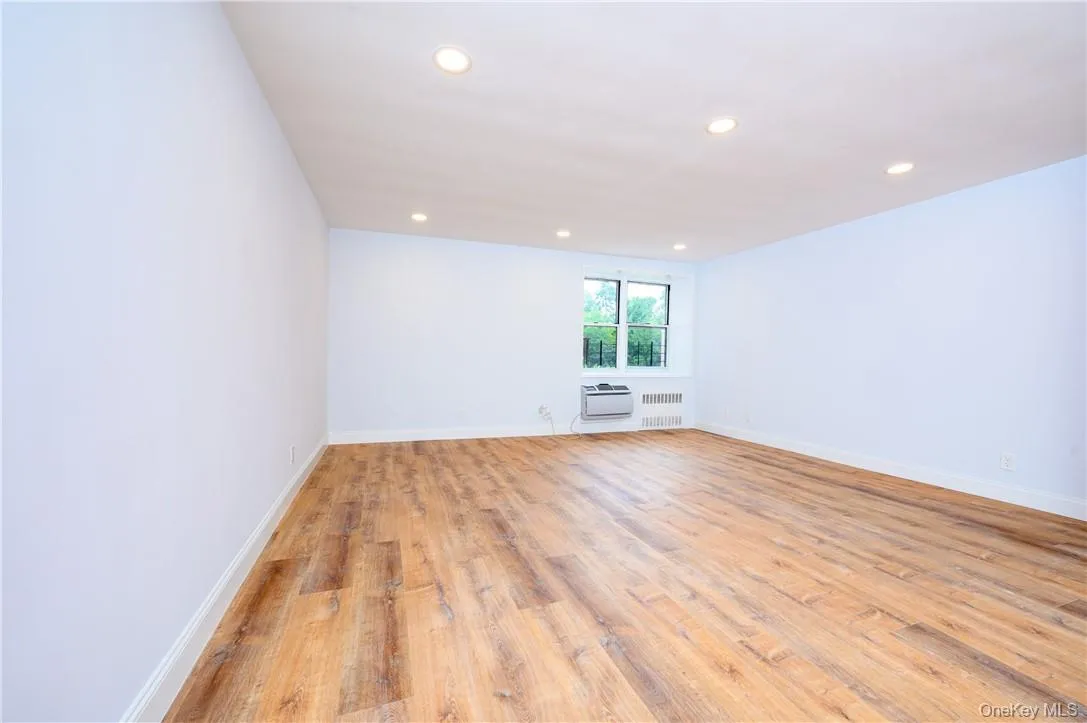 Spare room with radiator heating unit and light hardwood / wood-style floors Spare room with radiator heating unit and light hardwood / wood-style floors