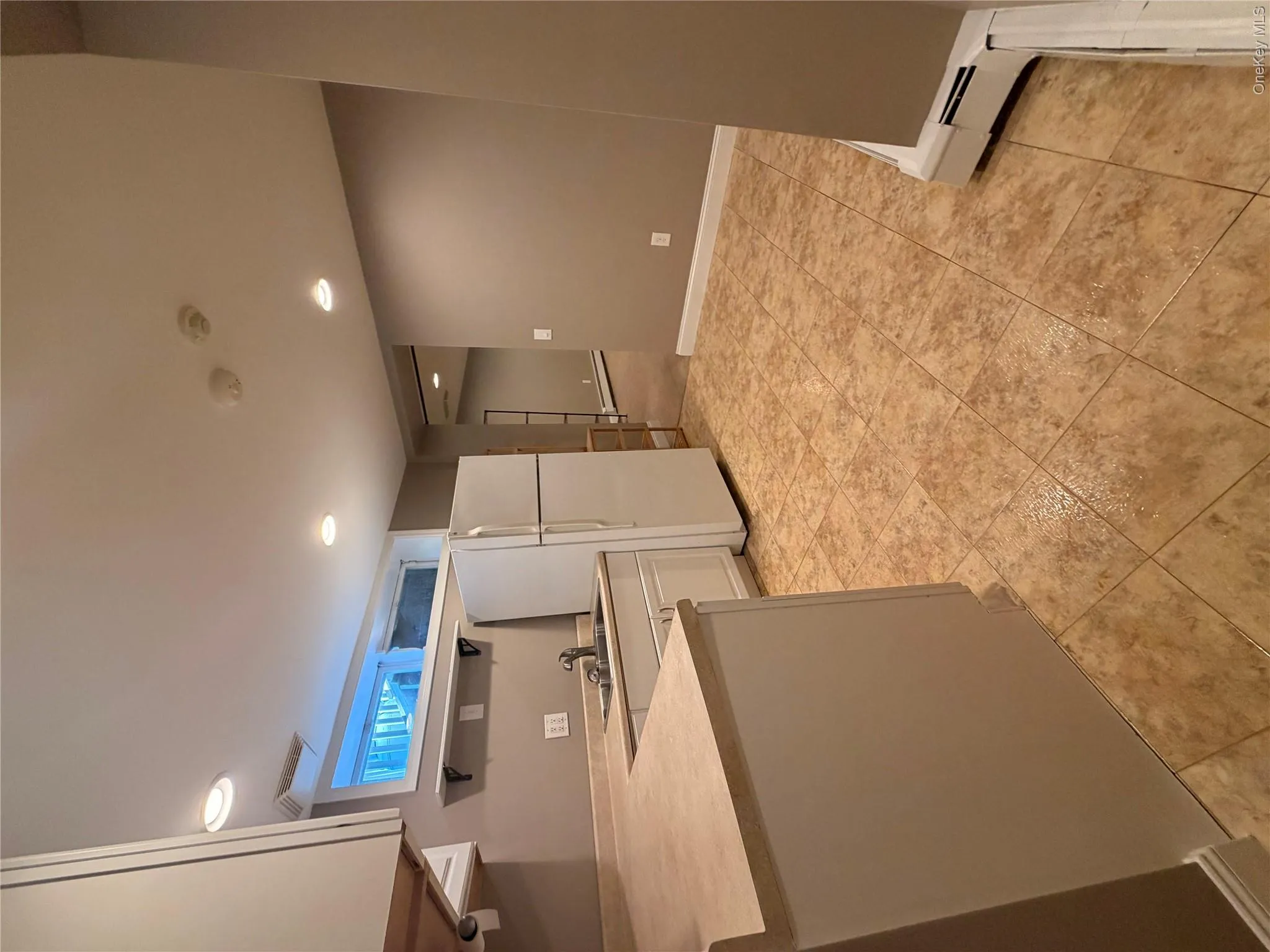 Kitchenette featuring an integrated sink, white cabinetry, light-toned countertops, tile flooring, and recessed lighting Kitchenette featuring an integrated sink, white cabinetry, light-toned countertops, tile flooring, and recessed lighting