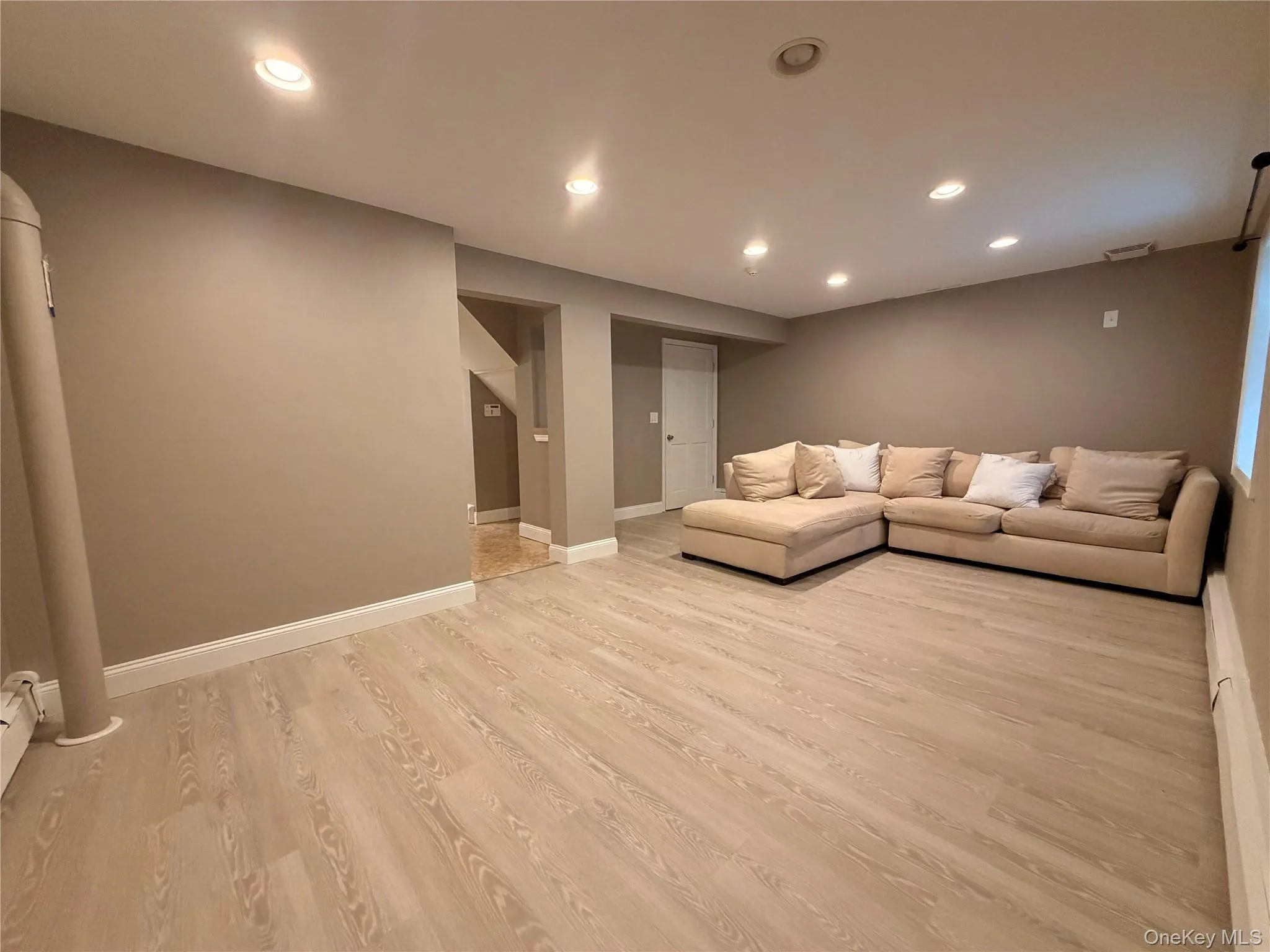 Spacious room featuring light wood-finish flooring, recessed lighting, and neutral wall paint Spacious room featuring light wood-finish flooring, recessed lighting, and neutral wall paint
