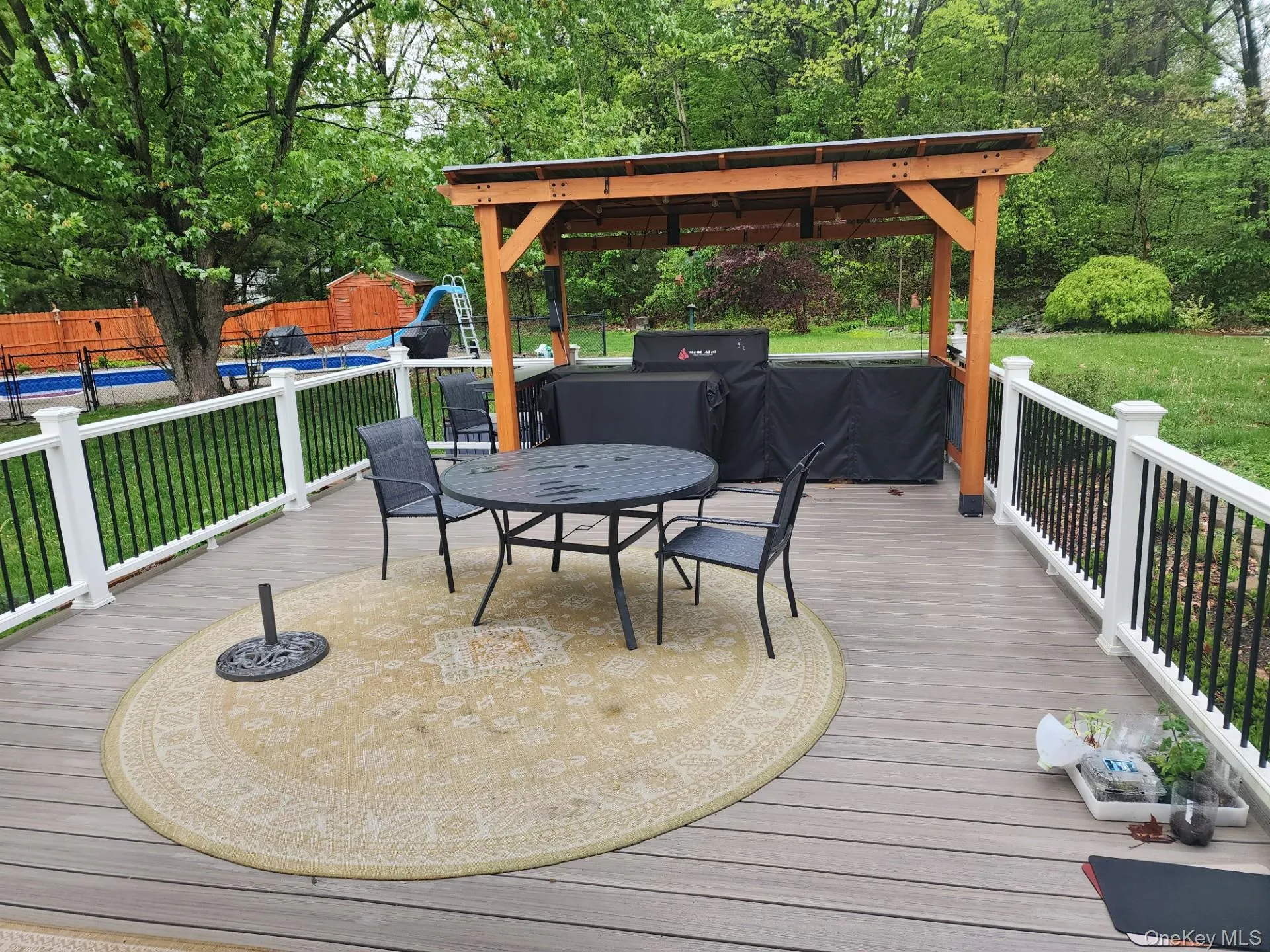 Huge party deck overlooking the backyard with covered barbeque station Huge party deck overlooking the backyard with covered barbeque station