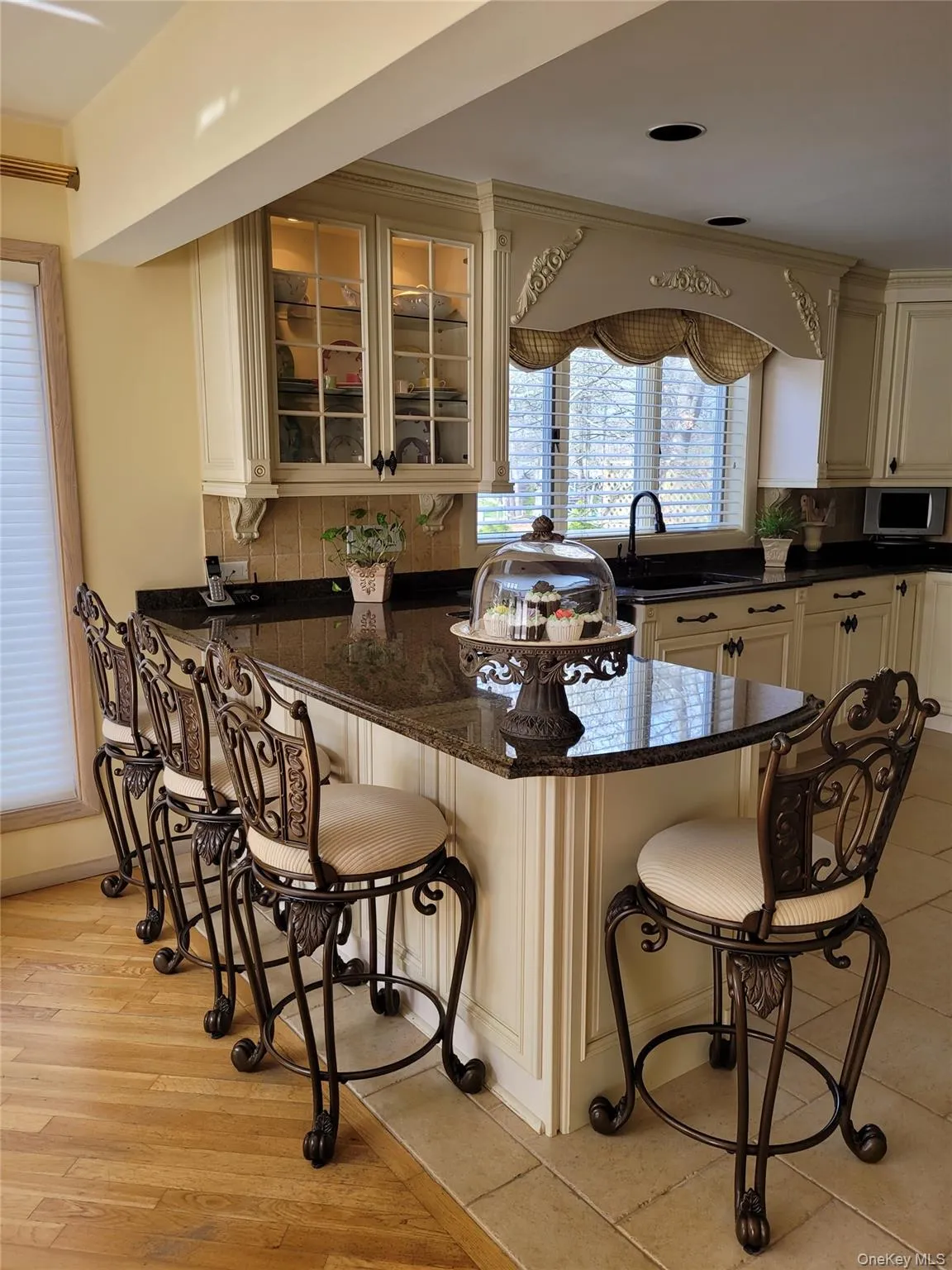 Kitchen island with a granite countertop, paneled base, and integrated seating Kitchen island with a granite countertop, paneled base, and integrated seating