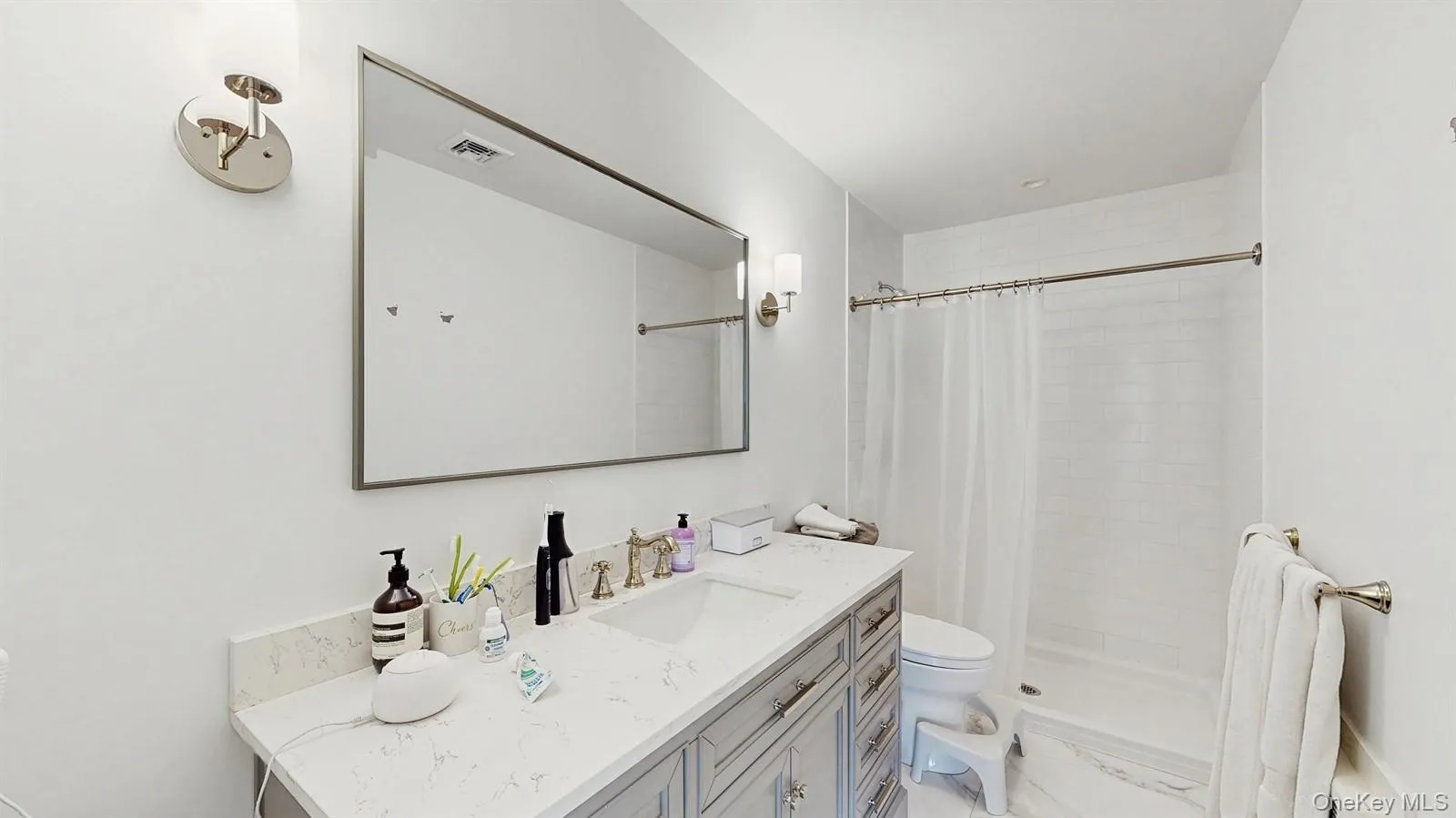 Full bathroom featuring visible vents, toilet, tiled shower, and vanity Full bathroom featuring visible vents, toilet, tiled shower, and vanity