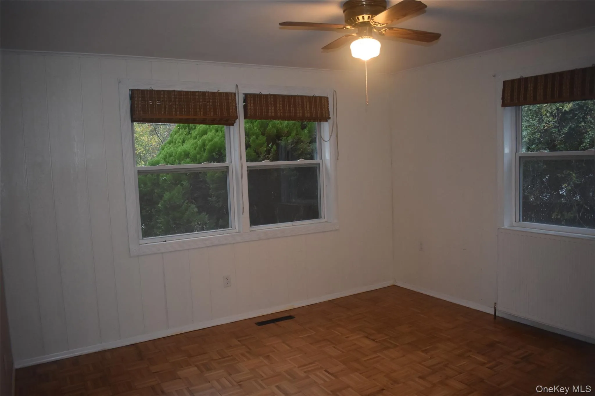 Empty room featuring a ceiling fan, crown molding, and wooden walls Empty room featuring a ceiling fan, crown molding, and wooden walls