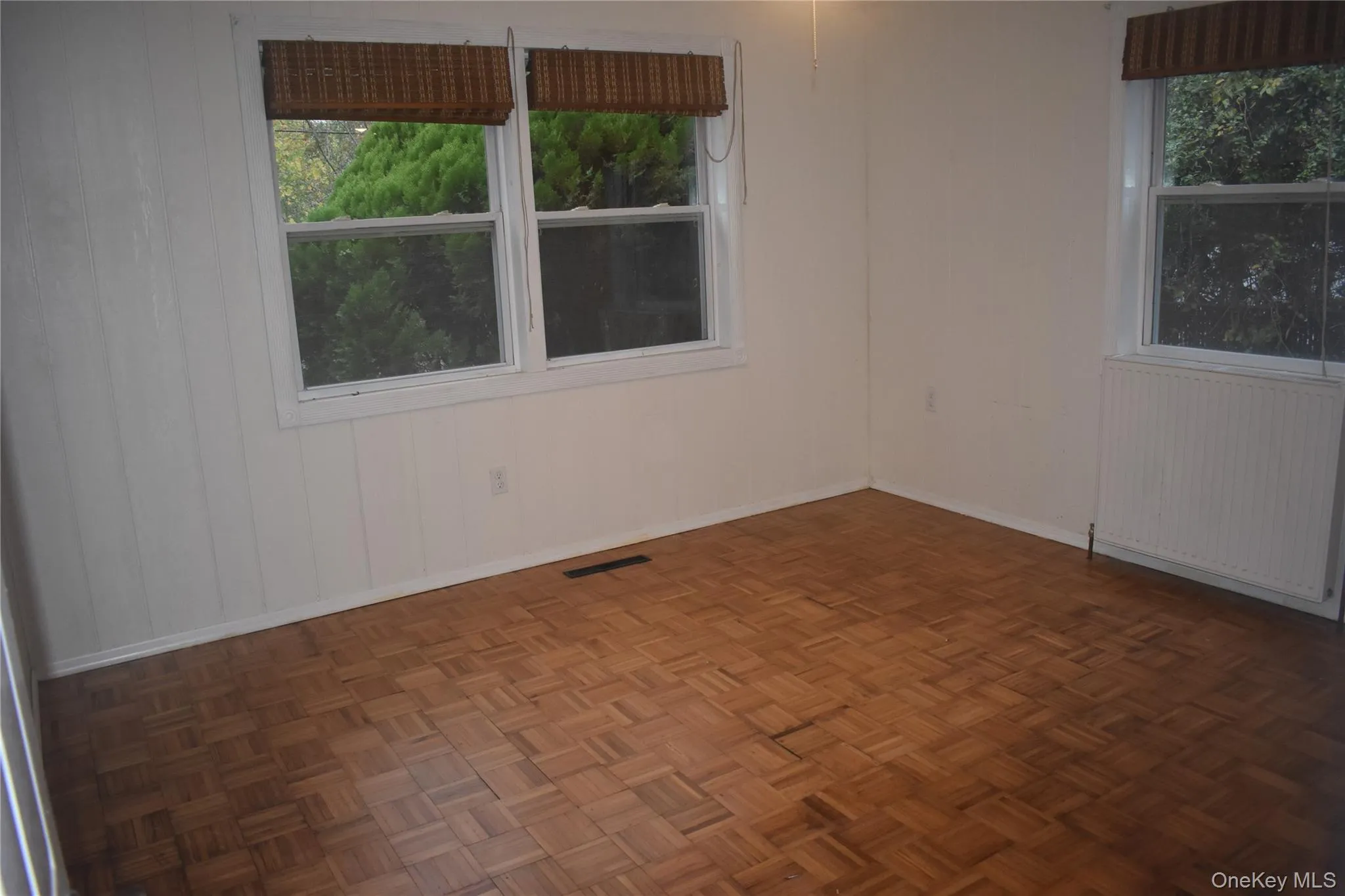 Spare room featuring radiator heating unit and wood walls Spare room featuring radiator heating unit and wood walls