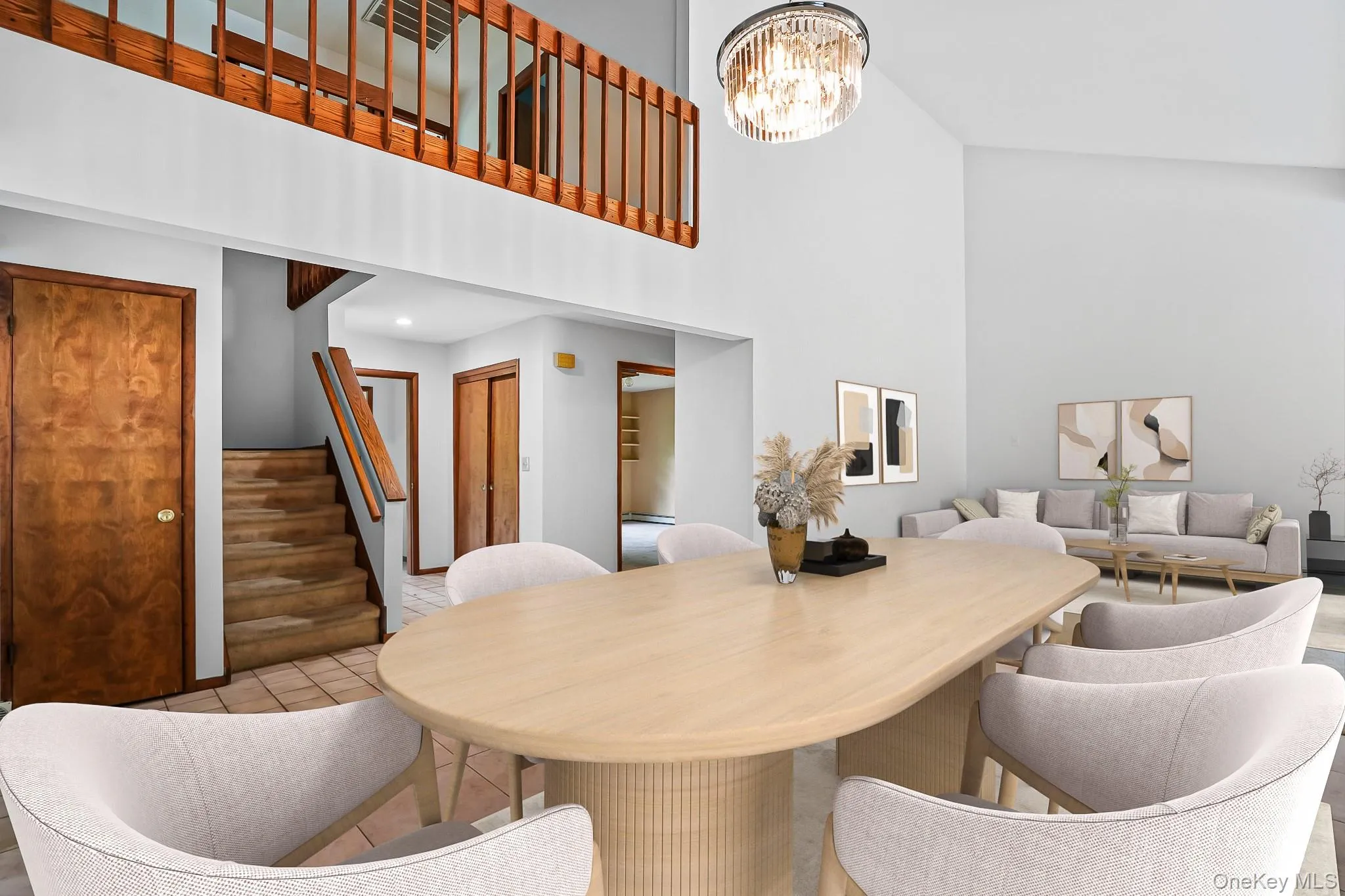 Vaulted ceilings above a dining area with a contemporary chandelier, featuring a wood-finish staircase and an upper-level wood railing Vaulted ceilings above a dining area with a contemporary chandelier, featuring a wood-finish staircase and an upper-level wood railing