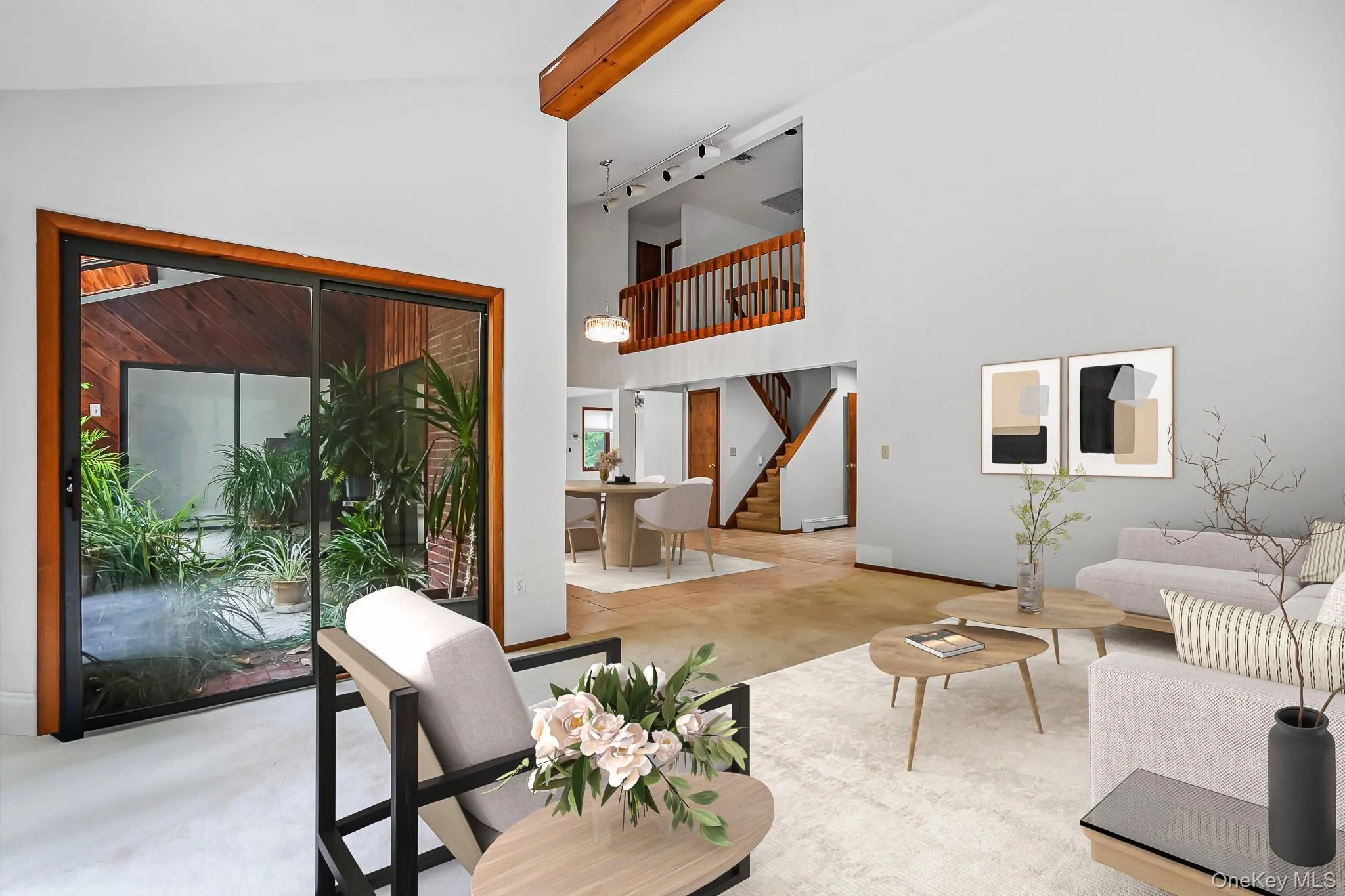 Vaulted ceilings with exposed wood beams, sliding glass doors opening to an enclosed courtyard, a multi-level layout with a prominent staircase, wood-finish flooring, and a second-story balcony overlooking the living space Vaulted ceilings with exposed wood beams, sliding glass doors opening to an enclosed courtyard, a multi-level layout with a prominent staircase, wood-finish flooring, and a second-story balcony overlooking the living space