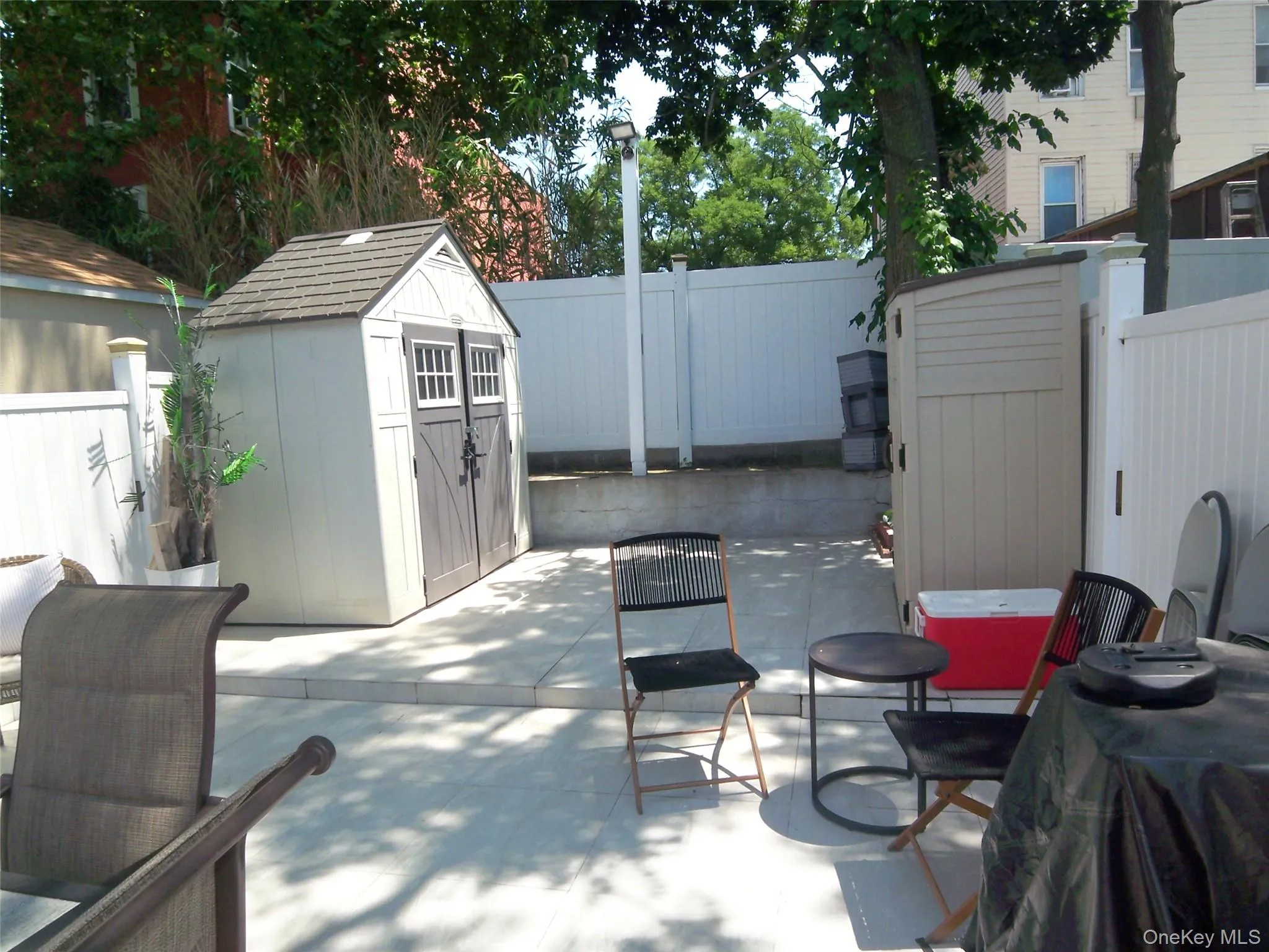 Paved patio area featuring two storage sheds Paved patio area featuring two storage sheds