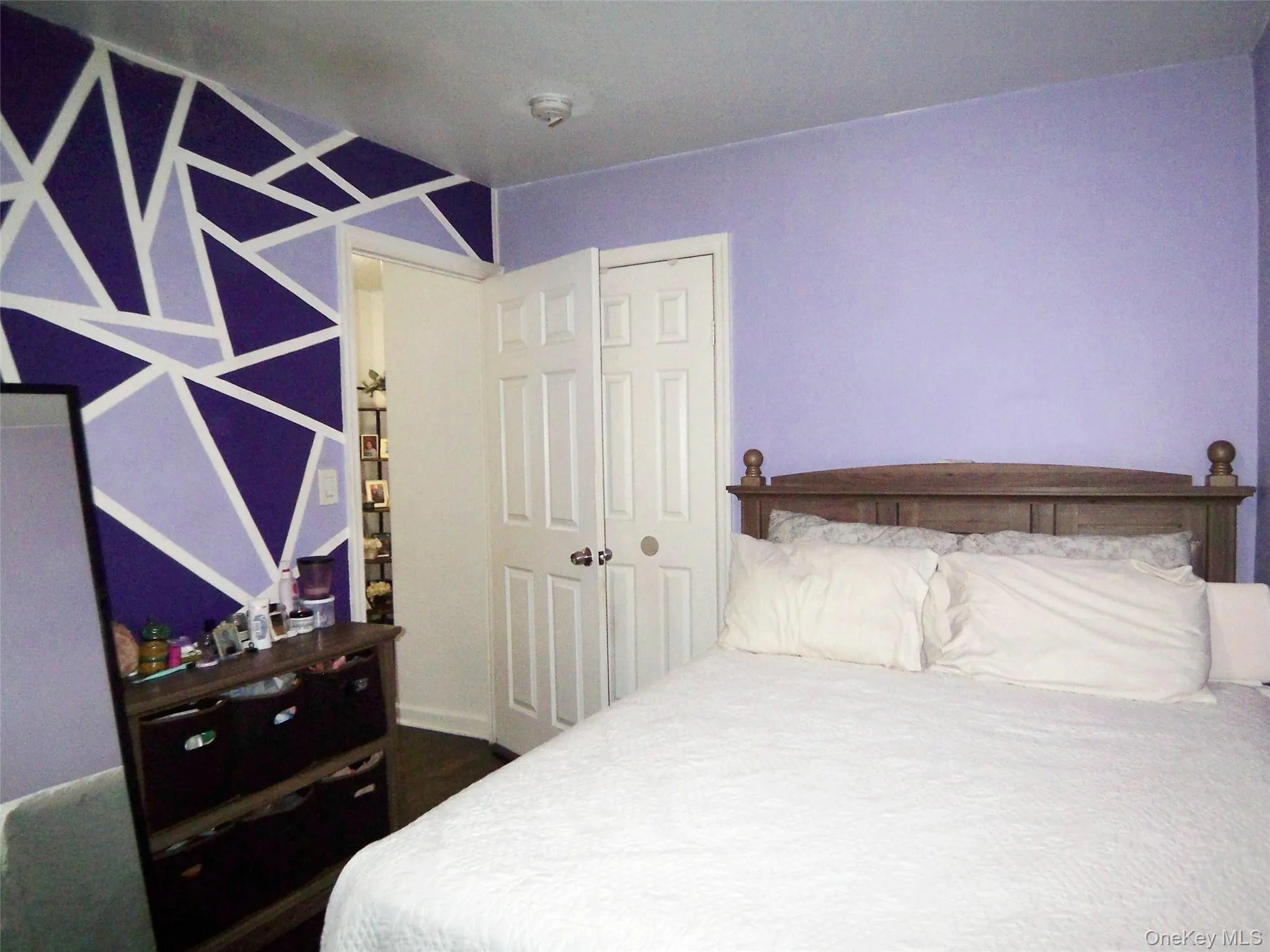 Room featuring a geometric accent wall in shades of purple Room featuring a geometric accent wall in shades of purple