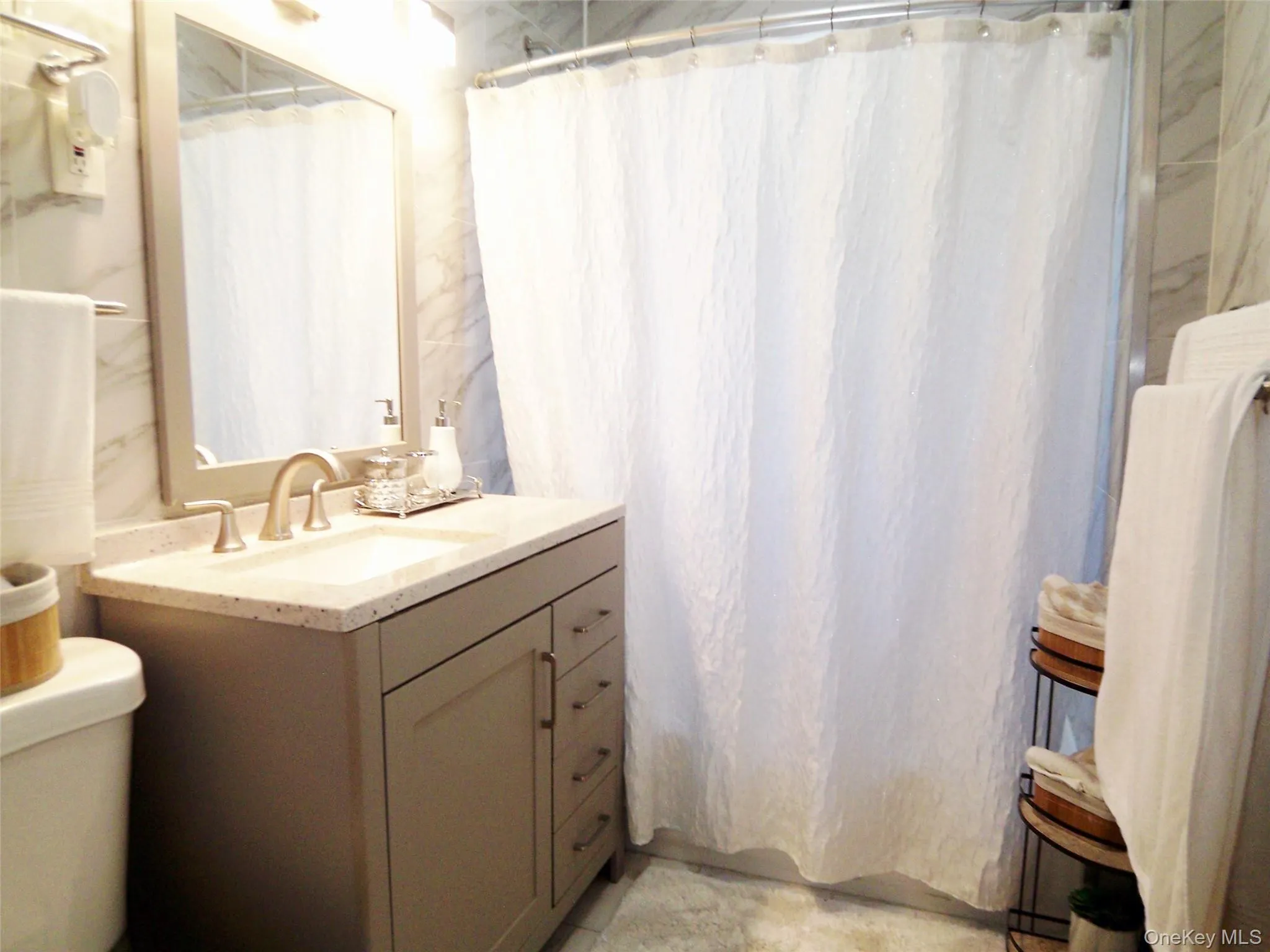 Contemporary vanity with a neutral-toned base, integrated sink, and light-toned countertop Contemporary vanity with a neutral-toned base, integrated sink, and light-toned countertop
