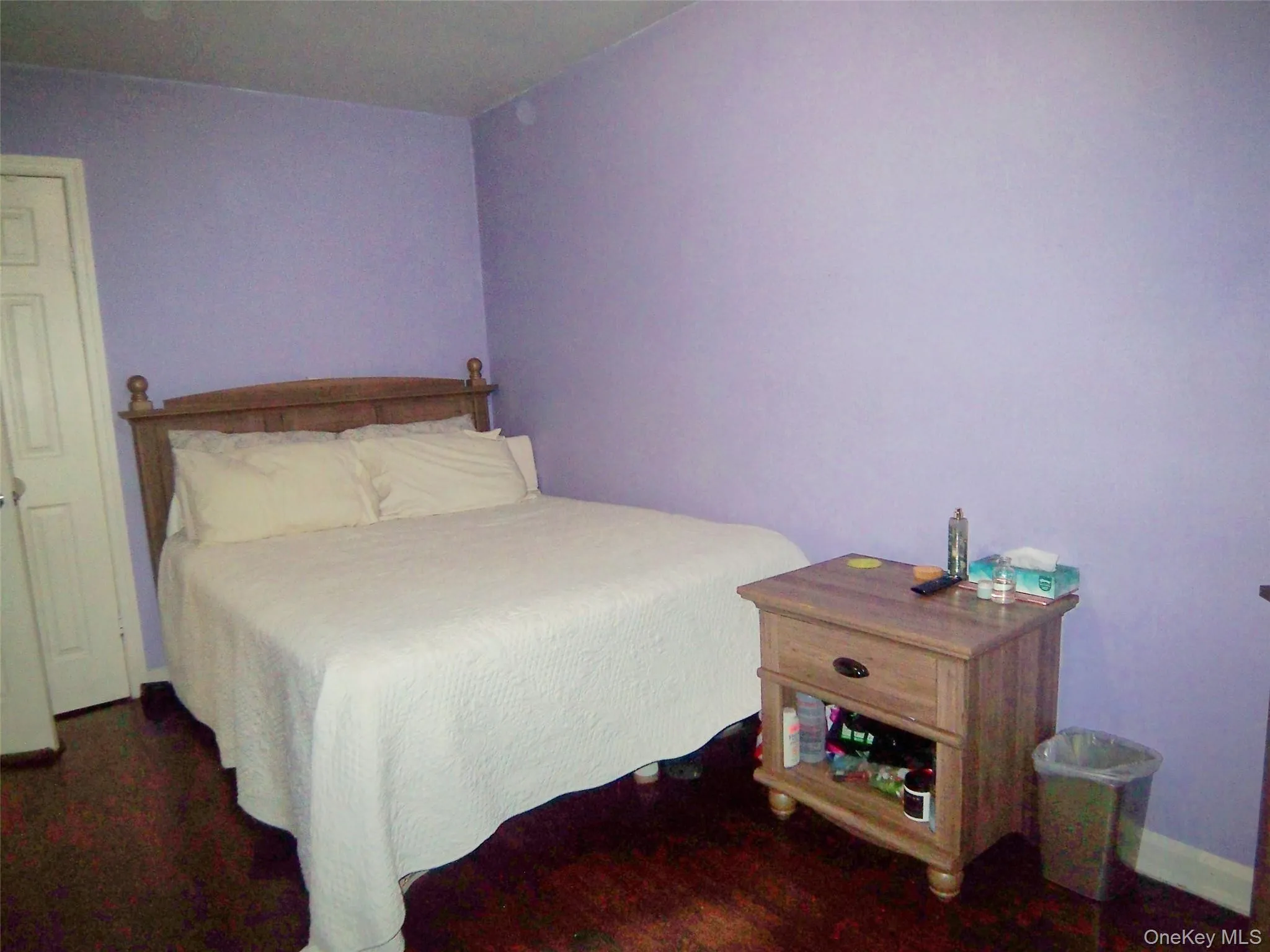 Room featuring rich wood-finish flooring and light lavender walls Room featuring rich wood-finish flooring and light lavender walls