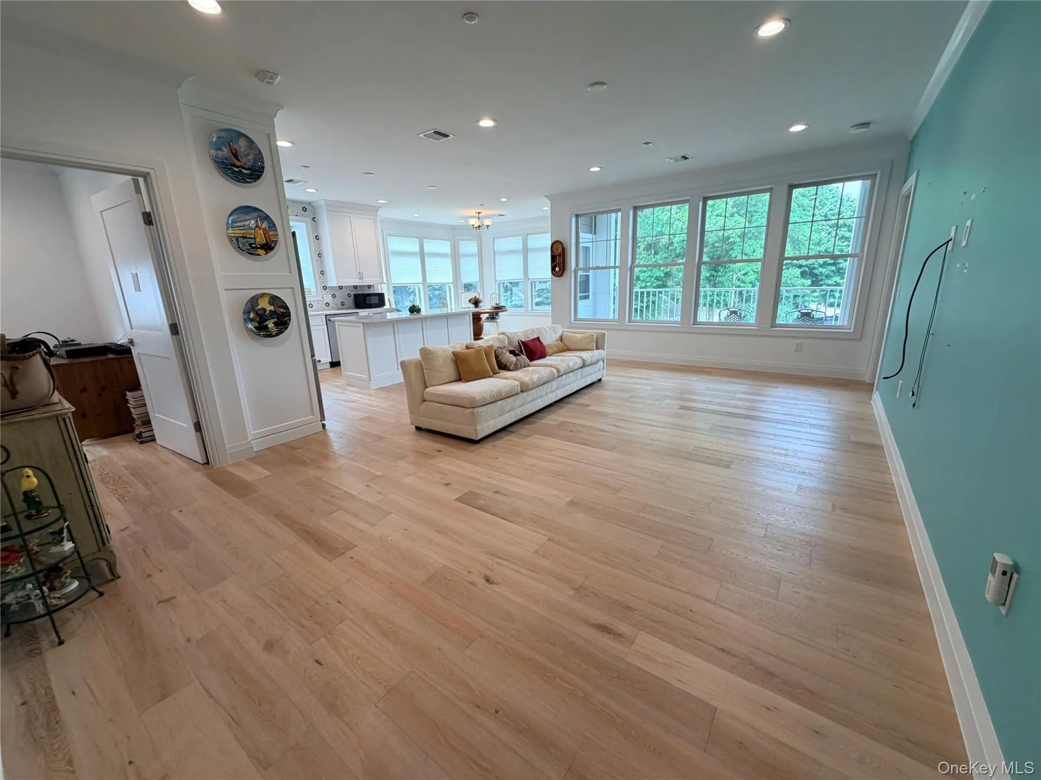 Open-concept living space featuring wood-finish flooring, recessed lighting, and expansive windows Open-concept living space featuring wood-finish flooring, recessed lighting, and expansive windows