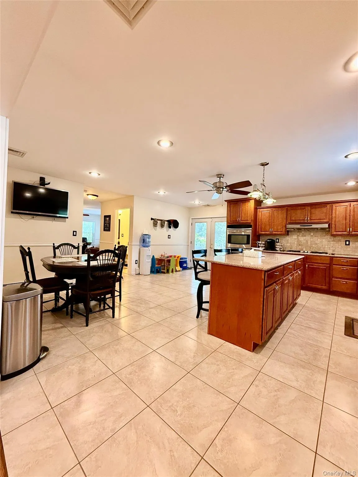 Spacious kitchen and dining area with large format tile flooring Spacious kitchen and dining area with large format tile flooring