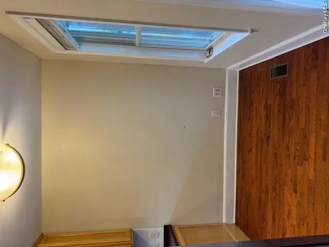 Compact room featuring wood-finish flooring, a double-hung window, and neutral wall tones Compact room featuring wood-finish flooring, a double-hung window, and neutral wall tones