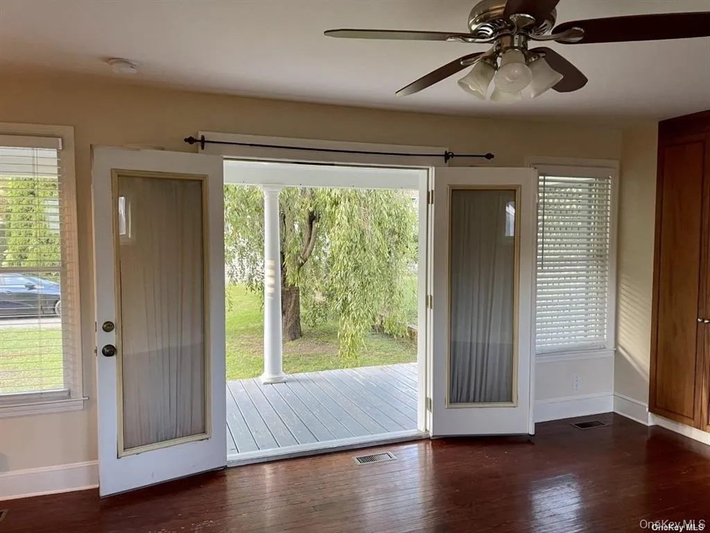 Double doors opening to an exterior porch with white columns Double doors opening to an exterior porch with white columns