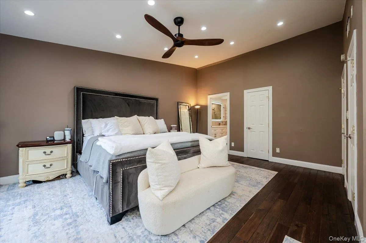Bedroom featuring wood-type flooring, baseboards, recessed lighting, connected bathroom, and a ceiling fan Bedroom featuring wood-type flooring, baseboards, recessed lighting, connected bathroom, and a ceiling fan