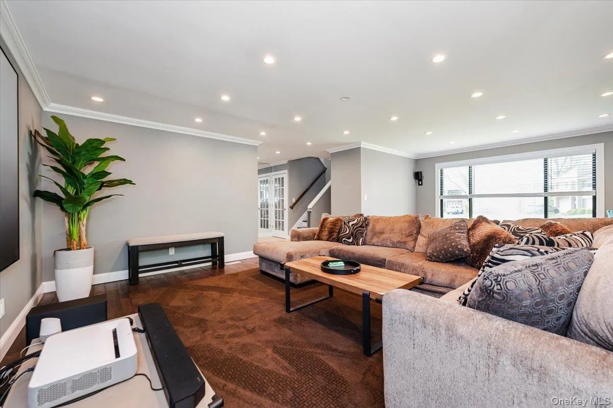 Living area with crown molding, stairs, wood finished floors, baseboards, and recessed lighting Living area with crown molding, stairs, wood finished floors, baseboards, and recessed lighting