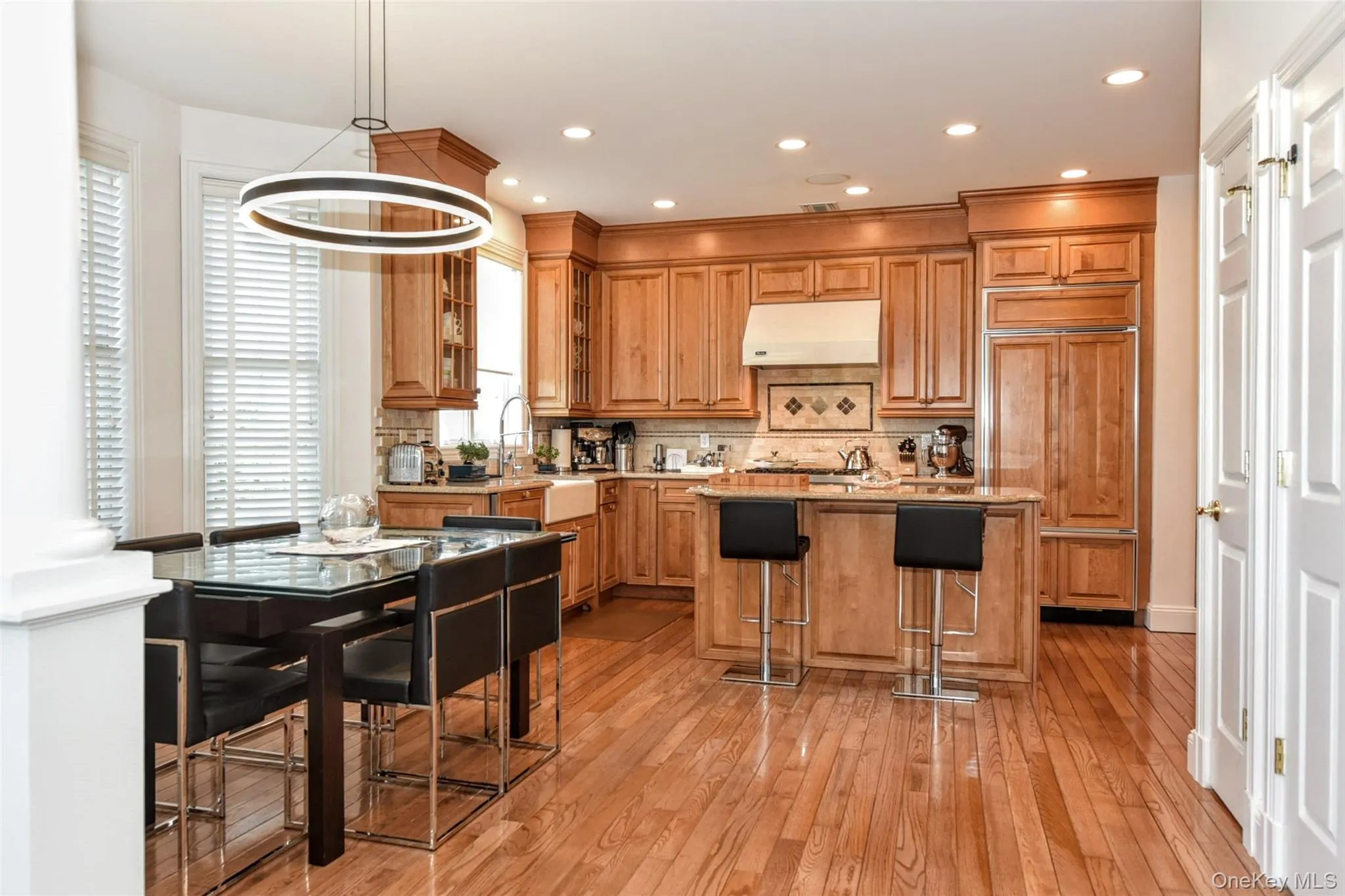 Open concept kitchen and dining area with hardwood flooring Open concept kitchen and dining area with hardwood flooring