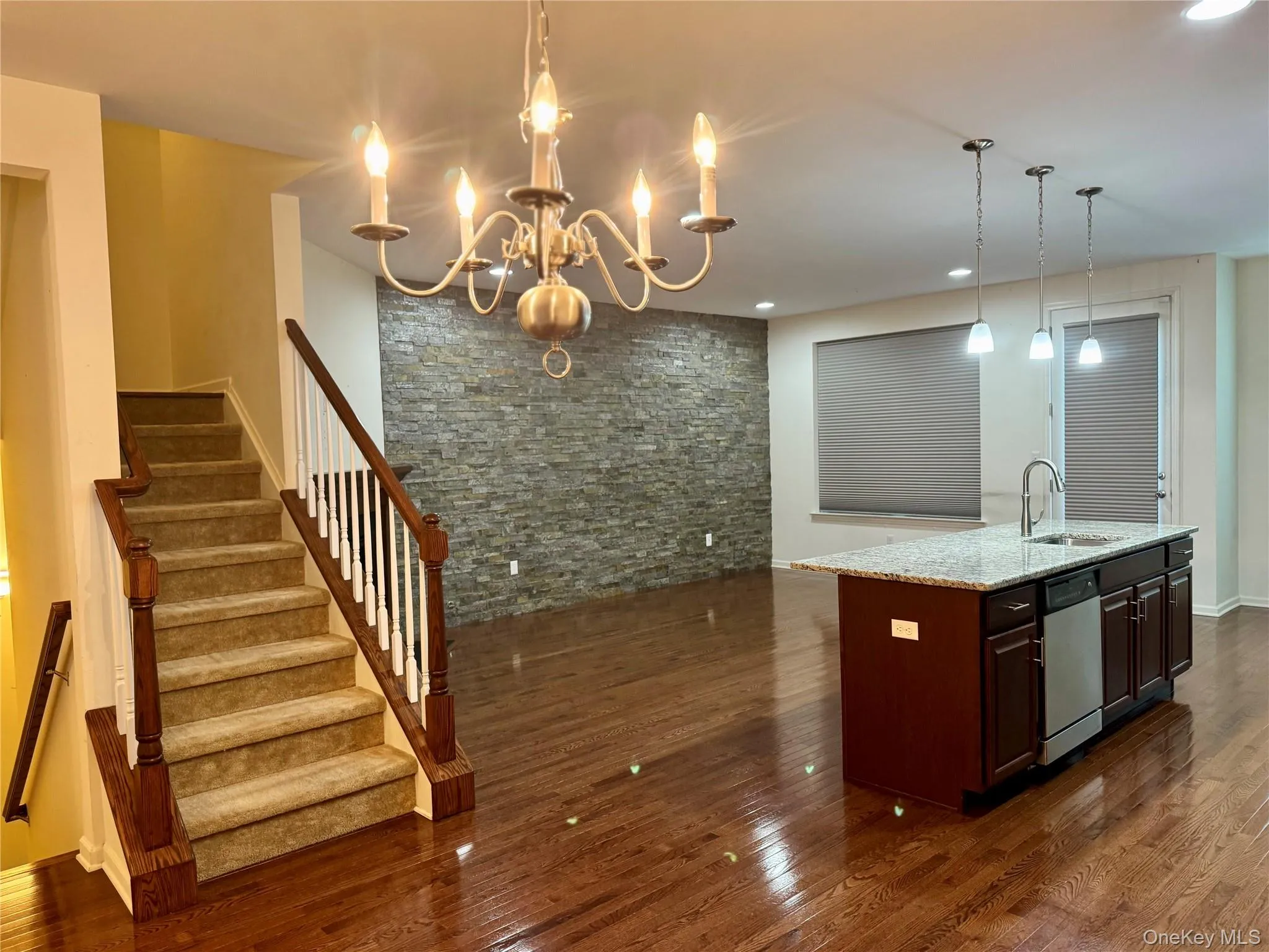 Kitchen with dishwasher, dark wood finished floors, light stone counters, a chandelier, and recessed lighting Kitchen with dishwasher, dark wood finished floors, light stone counters, a chandelier, and recessed lighting