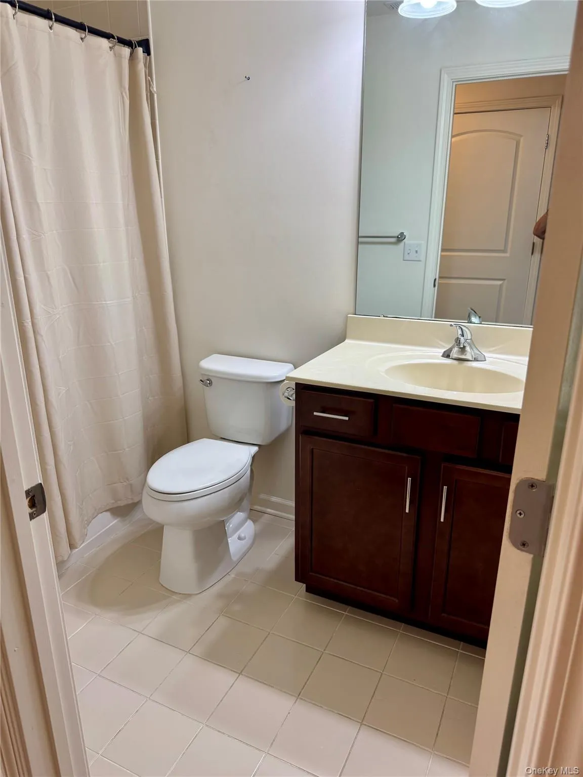 Bathroom featuring vanity, tile patterned flooring, and curtained shower Bathroom featuring vanity, tile patterned flooring, and curtained shower