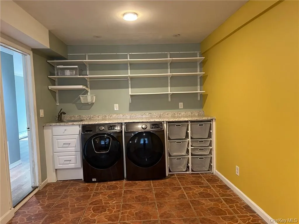 Washroom with washing machine and clothes dryer and sink with additional space Washroom with washing machine and clothes dryer and sink with additional space